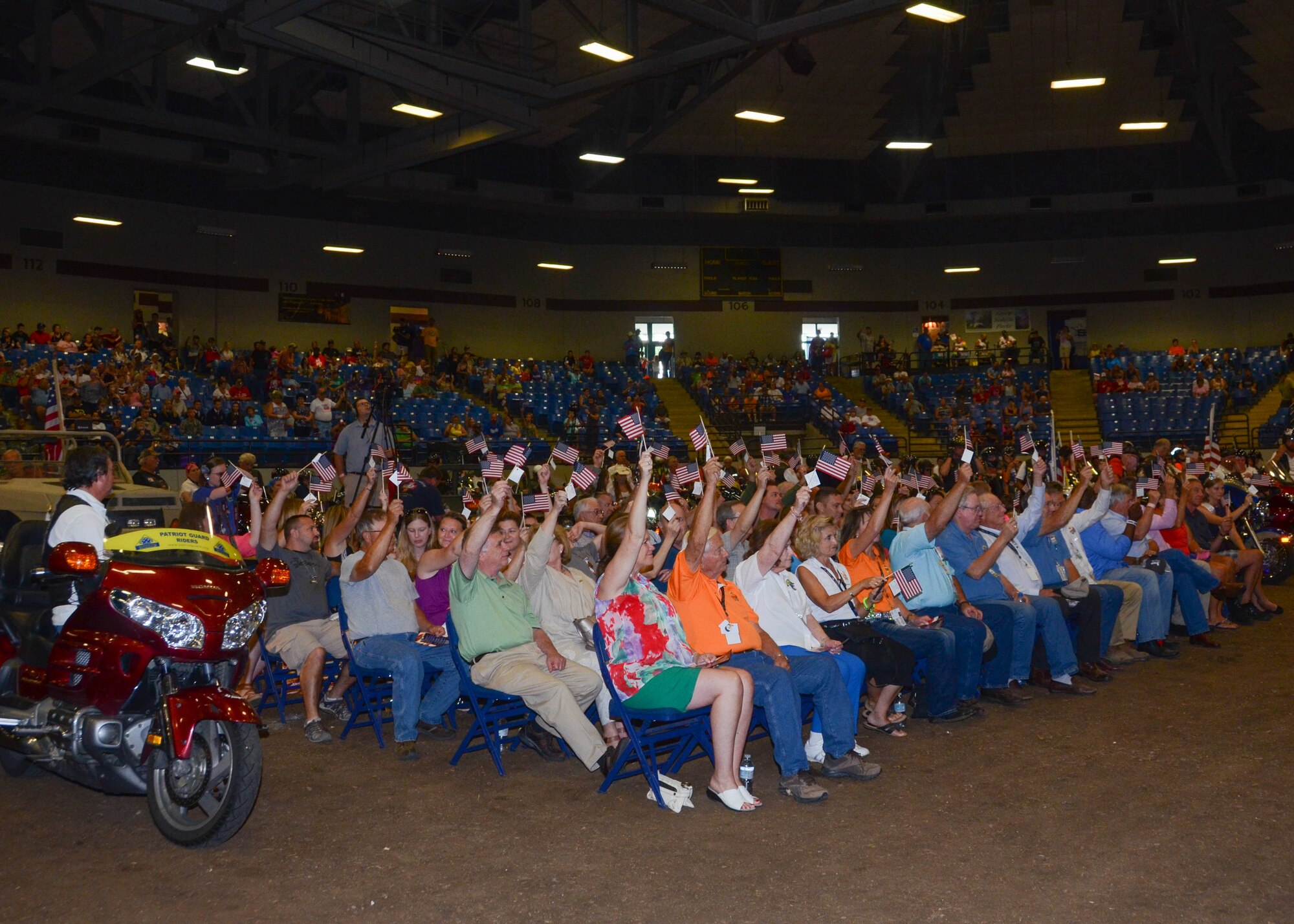 The crowd raises their flags in honor of all the Missouri servicemen and women past and present at the conclusion of the Military Appreciation day at the State Fair August 16, 2015. (U.S. Air National Guard photo by Staff Sgt. Brittany Cannon)


