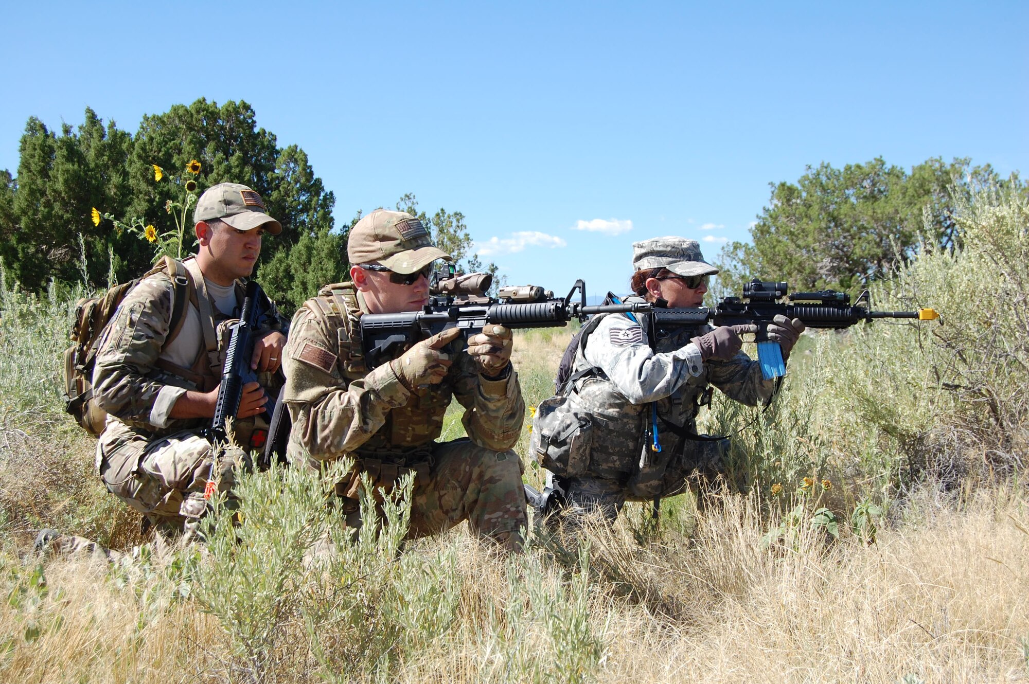 Senior Airman Ronnie Perez, combat medic, 460th Medical Group, 460th Space Wing, Senior Airman Adam Harkness, EOD operator, 140th Explosive Ordnance Disposal Flight, and Tech. Sgt. Kathy Sampson, patrolman,140th Security Forces Squadron, 140th Wing, Colorado Air National Guard, exercise squad movement tactics during a joint training day August 4 at Airburst Range, Fort Carson, Colo. (US Air National Guard photo by Capt. Kinder Blacke)