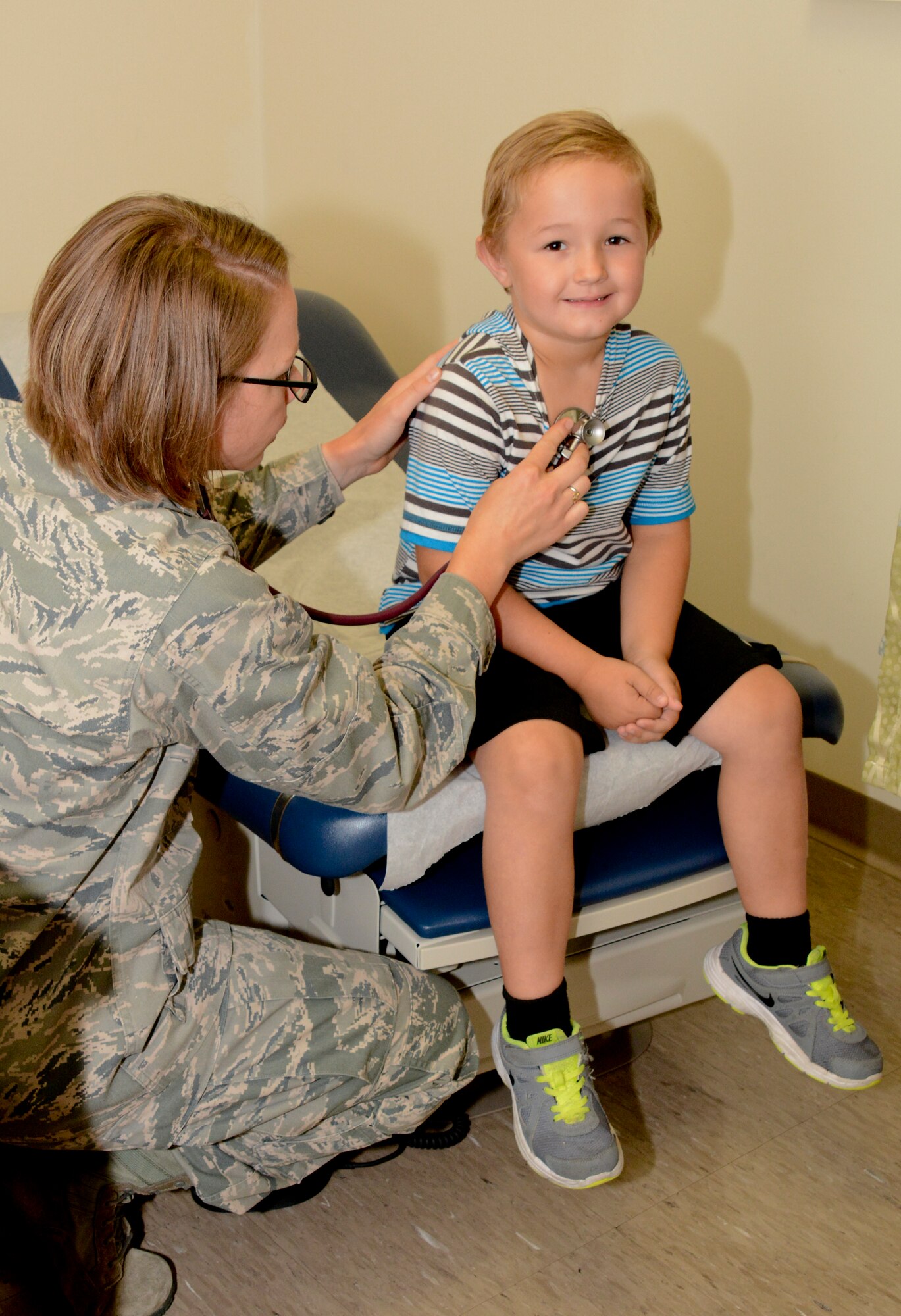 Capt. Rebecca Peebles, left, 60th Medical Operations Squadron third-year family medicine resident, administers a physical examination for a patient August 8, 2015, at David Grant Medical Center at Travis Air Force Base, Calif. The Family Medicine Clinic performed more than 150 sports physicals for military youth. (U.S. Air Force photo/Airman 1st Class Amber Carter)