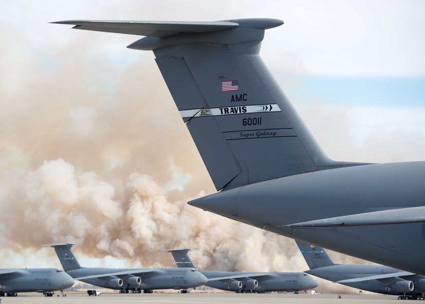 Firefighters from the 60th Civil Engineer Squadron at Travis Air Force Base, Calif., scrambled to extinguish a grass fire near the base's flightline, August 10, 2015. Though no aircraft, buildings or people were in immediate danger, the fire eventually scorched more than 125 acres as it moved outside the base perimeter, where local fire crews responded. The cause of the fire is under investigation. (U.S. Air Force photo by Ken Wright)