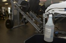 A bottle of disinfectant hangs on a towel rack in a workout room in the fitness center, Aug. 18, 2015, at McConnell Air Force Base, Kan. As a part of maintaining the fitness center, Mugford is responsible for wiping down workout equipment in the fitness center at the end of each shift. (U.S. Air Force photo by Senior Airman Colby L. Hardin)