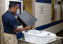 Senior Airman Matt Mugford, 22nd Force Support Squadron fitness journeyman, empties a rag bin, Aug. 18, 2015, at McConnell Air Force Base, Kan. Mugford is responsible for checking every room and bringing in clean replacement towels for customers’ use every hour during his shift. (U.S. Air Force photo by Senior Airman Colby L. Hardin)