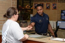 Senior Airman Matt Mugford, 22nd Force Support Squadron fitness journeyman, loans a padlock to a customer, Aug. 18, 2015, at McConnell Air Force Base, Kan. The fitness center here rents locks to customers to help secure their gear while at the gym. (U.S. Air Force photo by Senior Airman Colby L. Hardin)