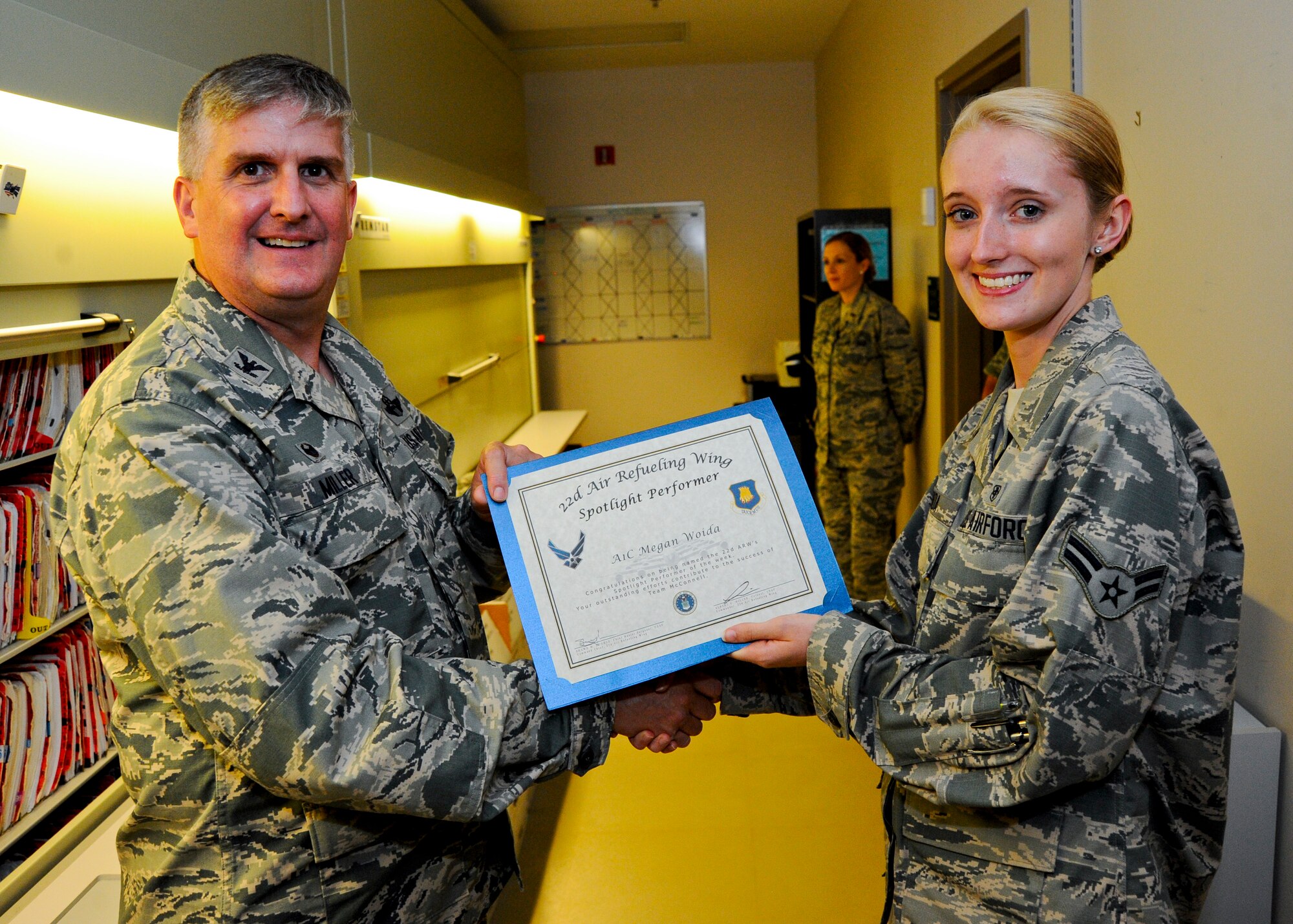 Airman 1st Class Megan Woida, 22nd Medical Support Squadron outpatient medical records technician, poses with Col. Albert Miller, 22nd Air Refueling Wing commander, Aug.18, 2015, at McConnell Air Force Base, Kan. Woida was selected as the wing spotlight performer for the week of Aug. 9 -15 for her outstanding work ethic and high patient satisfaction rate in her five months on station. (U.S. Air Force photo by Senior Airman Victor J. Caputo)