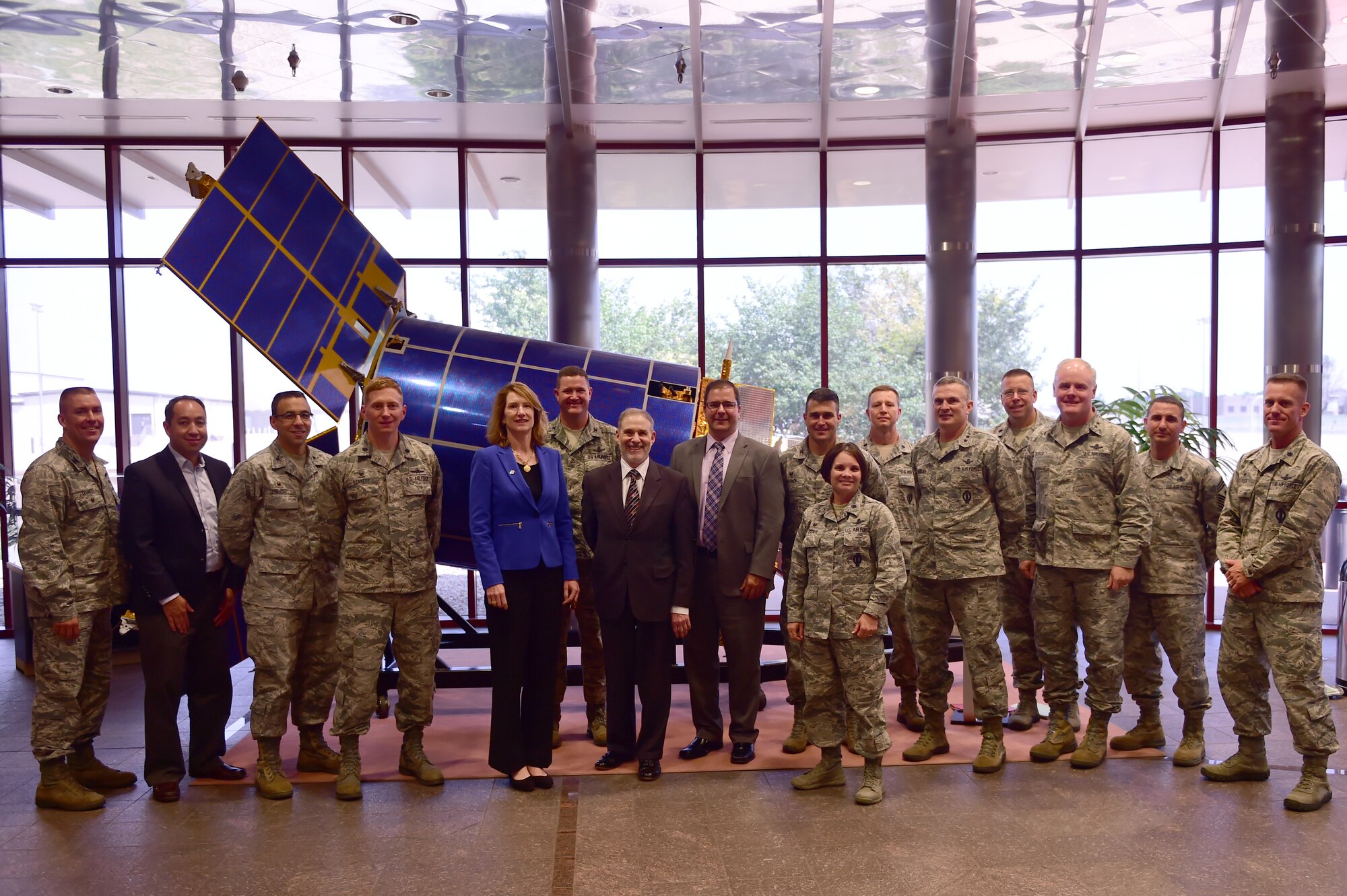 Base leadership poses in front of the Defense Support Program satellite in the Mission Control Station with Lisa Disbrow, Acting Under Secretary of the Air Force, Aug. 18, 2015, on Buckley Air Force Base, Colo. Ms. Disbrow interacted with Airmen in order to gain a better understanding of the mission conducted by the 460th SW.  (U.S. Air Force photo by Airman 1st Class Luke W. Nowakowski/Released)