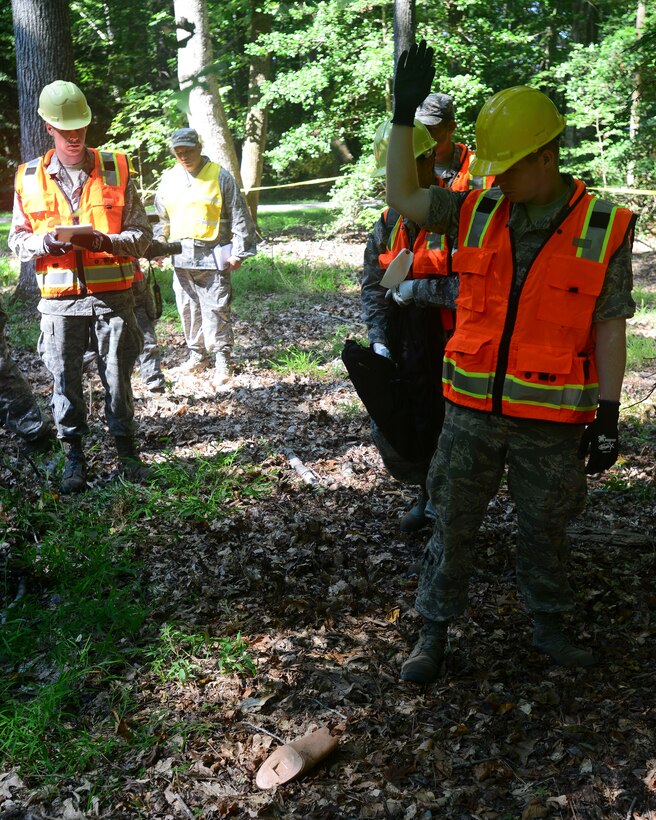 U.S. Air Force Airmen locate a body part during a helicopter training exercise at Fort Eustis, Va., Aug. 13, 2015. The Airmen were responsible for scanning the area surrounding a simulated downed helicopter during the exercise to recover any limbs and or bodies found during the search. (U.S. Air Force photo by Staff Sgt. Ciara Gosier/Released)