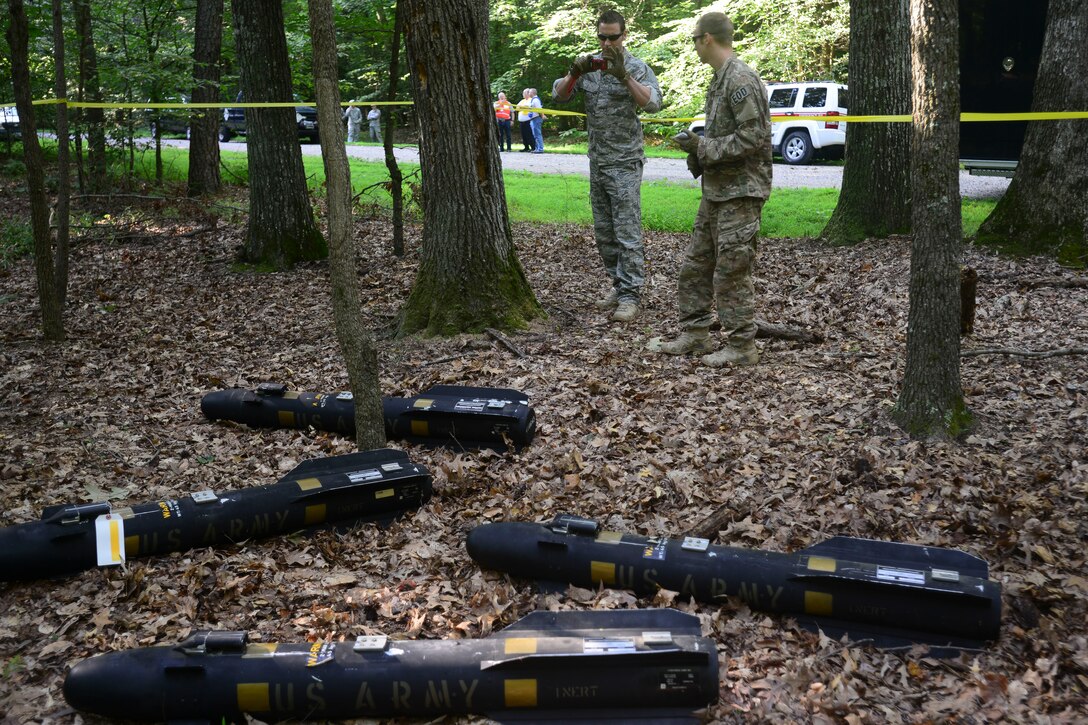 U.S. Air Force Airmen from the 633rd Civil Engineer Squadron Explosive Ordnance Disposal unit capture images of training missiles during a helicopter training exercise at Fort Eustis, Va., Aug. 13, 2015. EOD identified training hellfire missiles and accounted for and documented the location of the missiles during the exercise. (U.S. Air Force photo by Staff Sgt. Ciara Gosier/Released)     
