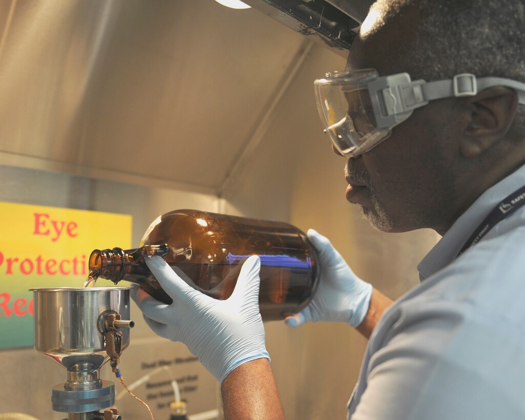 Reggie Moore, 11th Logistics Readiness Squadron fuels technician, performs a bottle-method test Aug. 19, 2015, on Joint Base Andrews, Md. This test checks the solid content in the fuel to ensure the delivery is free of particulate matter. (U.S. Air Force photo by Senior Airman Preston Webb/RELEASED)