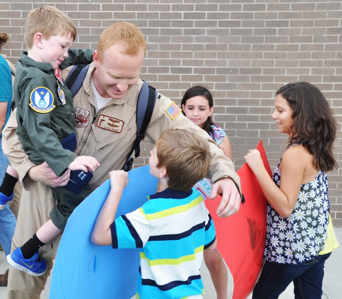 Capt. Greg Brashier, 18th Air Refueling Squadron pilot, holds his son as he greets his nephew Aug. 18, 2015, at McConnell Air Force Base. Brashier had just returned had just returned from a deployment to Southwest Asia, where he helped provide support to the 379th Air Expeditionary Wing. (U.S. Air Force photo by Tech. Sgt. Abigail Klein)