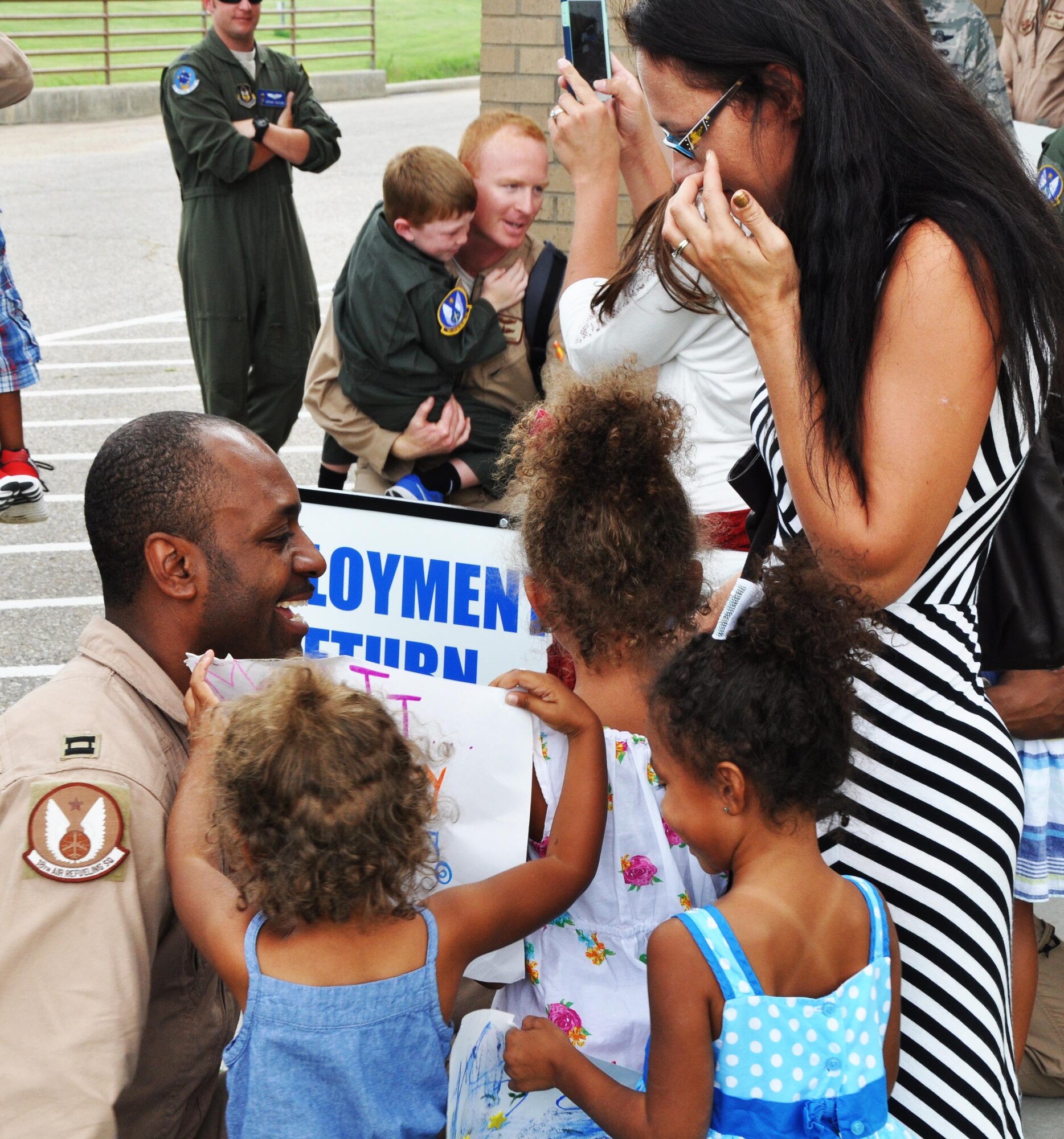 (Left to right)) Capt. Damian Baskerville, 18th Air Refueling Squadron pilot, greets his daughters and his spouse, Nicole, after returning from a deployment to Southwest Asia Aug. 18, 2015, at McConnell Air Force Base, Kan. While deployed, Baskerville conducted air refueling missions in support of ongoing U.S. operations overseas. (U.S. Air Force photo by Tech. Sgt. Abigail Klein)