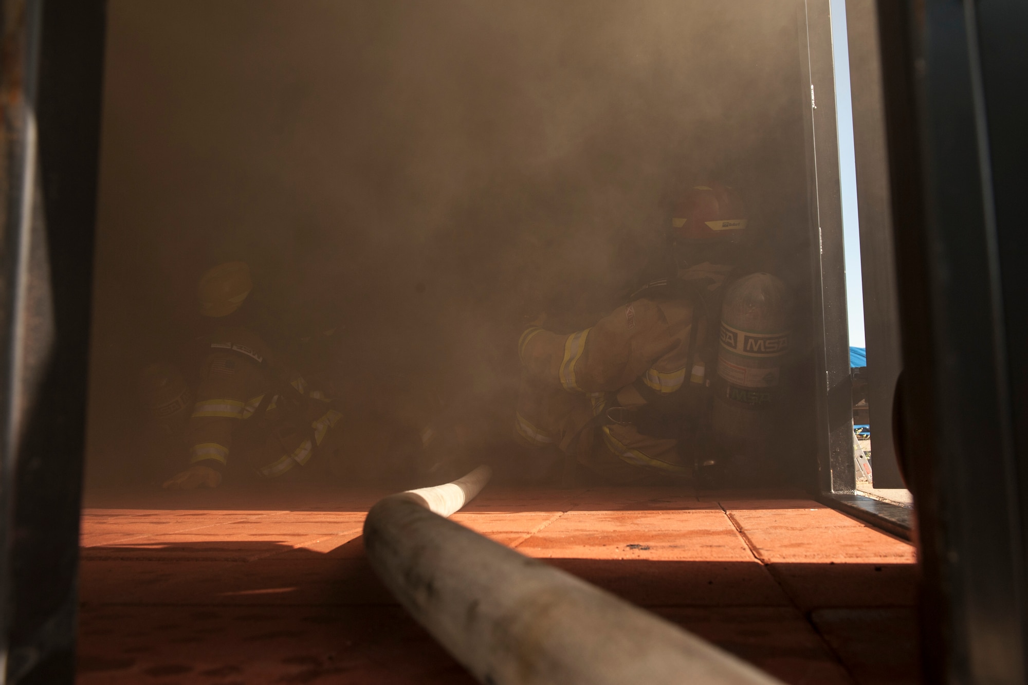 CHEYENNE MOUNTAIN AIR FORCE STATION, Colo. – Firefighters with the 721st Civil Engineer Squadron evaluate how different amounts of oxygen affect how smoke and fire spread during flash over fire training at the base training area, Aug. 18, 2015. This type of training helps them prepare for flash over fires in real world situations. (U.S. Air Force photo by Airman 1st Class Rose Gudex)