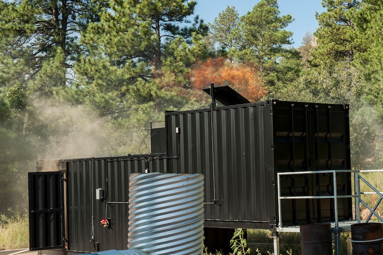 CHEYENNE MOUNTAIN AIR FORCE STATION – Fire escapes through a vent during the 721st Civil Engineer Squadron firefighters’ flash over fire training at the base training area, Aug. 18, 2015. The new equipment allows them to contain a fire and experience how the smoke and fire react to different amounts of oxygen let into the small space. (U.S. Air Force photo by Airman 1st Class Rose Gudex)