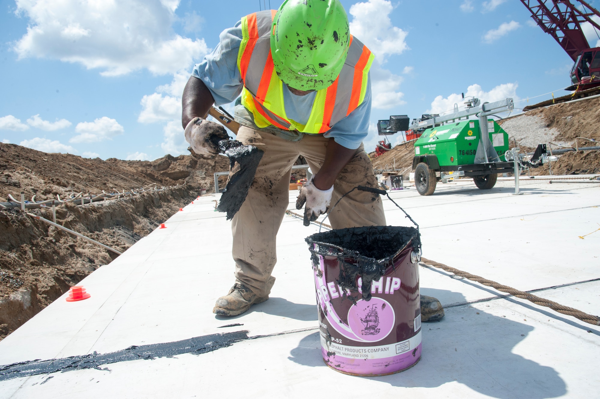 Charles Rogers, Allan Myers construction worker, seals concrete box seams with tar August 12, 2015, on Dover Air Force Base, Del. Once dried, the boxes will then be covered and compacted with dirt to guarantee the culvert does not fluctuate over time. The work is part of a $98.3 million runway repair project. (U.S. Air Force photo/Senior Airman Jared Duhon)