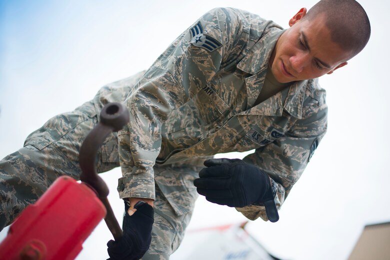 Senior Airman Dominic Koah, 11th Civil Engineer Squadron water and fuels systems specialist, opens a water valve outside Hangar 13 on Joint Base Andrews, Md., Aug. 19, 2015. In addition to repairing the facilities fire suppression system, they also checked for leaks inside and outside of the hangar. (U.S. Air Force photo by Staff Sgt. Chad C. Strohmeyer)(Released)