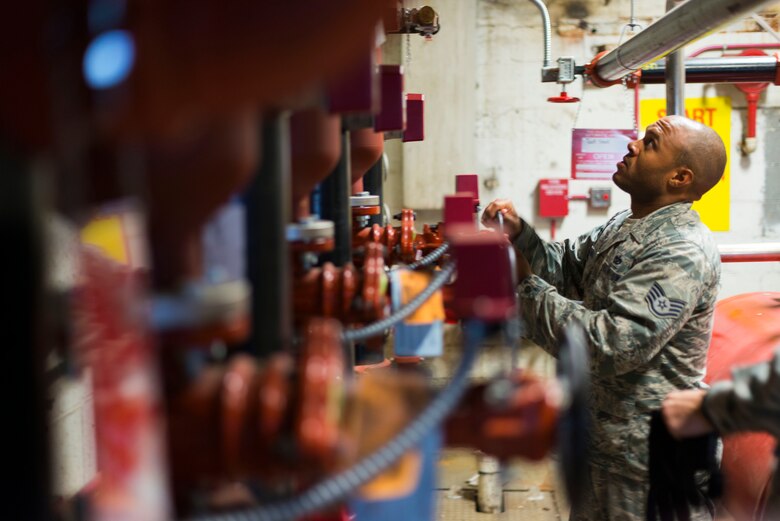 Staff Sgt. Lewis Thomas, 11th Civil Engineer Squadron water and fuels systems specialist, checks a pressure gauge at Hangar 13 on Joint Base Andrews, Md., Aug. 19, 2015. Thomas and his crew were repairing the facilities fire suppression system, which is crucial for hangars that store aircraft. (U.S. Air Force photo by Staff Sgt. Chad C. Strohmeyer)(Released)