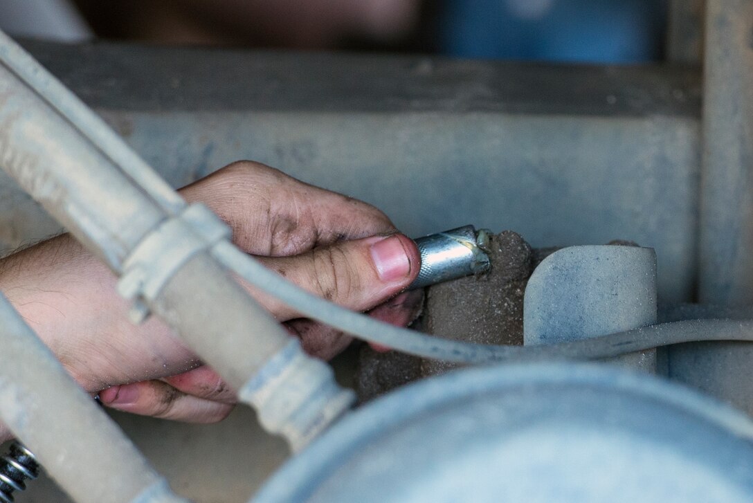 U.S. Air Force Airman 1st Class Samuel Reilly, 23d Logistics Readiness Squadron vehicle maintenance technician, uses a grease gun on a street sweeper Aug. 10, 2015, at Moody Air Force Base, Ga. Reilly is a part of the multipurpose maintenance shop which performs general purpose, tactical, construction and aircraft maintenance support type vehicles. (U.S. Air Force photo by Airman 1st Class Greg Nash/Released)