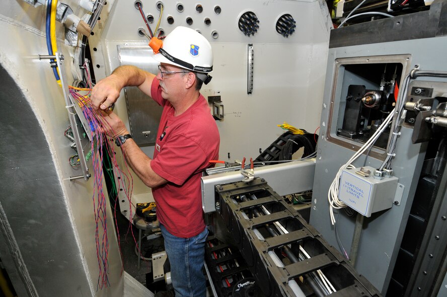 Randy Vinke, an ATA electrician with the Propulsion Wind Tunnel Facility Test Operations group at Arnold Engineering Development Complex, installs wires for the interface panels that are used to connect the test model instrumentation to a data system. The installation occurs in the PWT four-foot Transonic Wind Tunnel Captive Trajectory Support, or CTS, system, which contains a newly designed and fabricated mechanism that enables a test model to have six degrees of motion: pitch, roll, yaw, axial, horizontal and vertical. The CTS is used to conduct staging and store separation testing. (U.S. Air Force photo/Rick Goodfriend) 