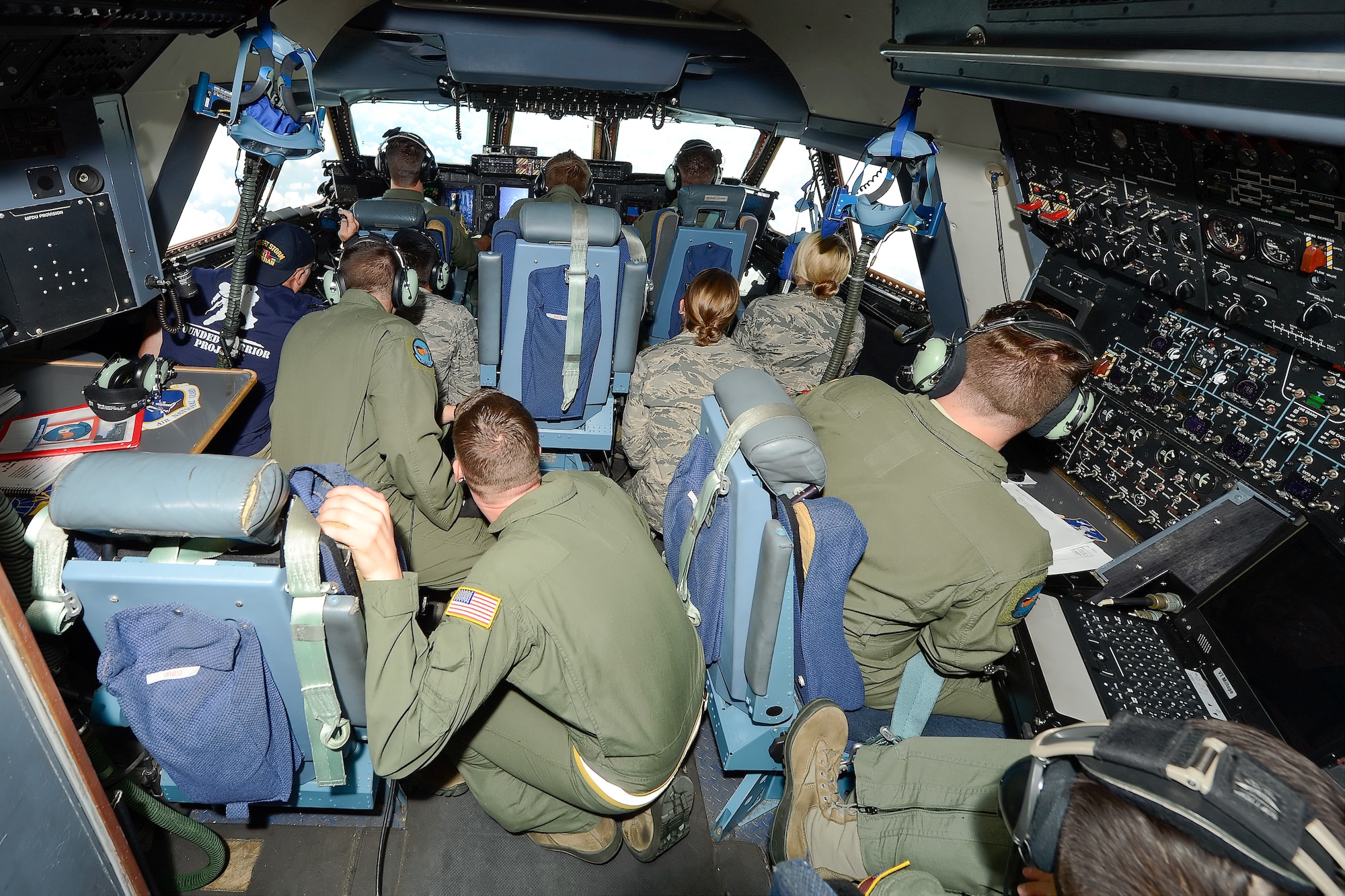Aircrew and incentive flyers huddle in the flight deck of a C-5M Super Galaxy during a training flight Aug. 11, 2015, at Dover Air Force Base, Del. The incentive flyers were observing air-refueling training being conducted between a Dover based C-5M and a KC-135R Stratotanker from a 171st Air Refueling Wing, Pittsburgh International Airport, Pennsylvania Air National Guard. (U.S. Air Force photo/Greg L. Davis)