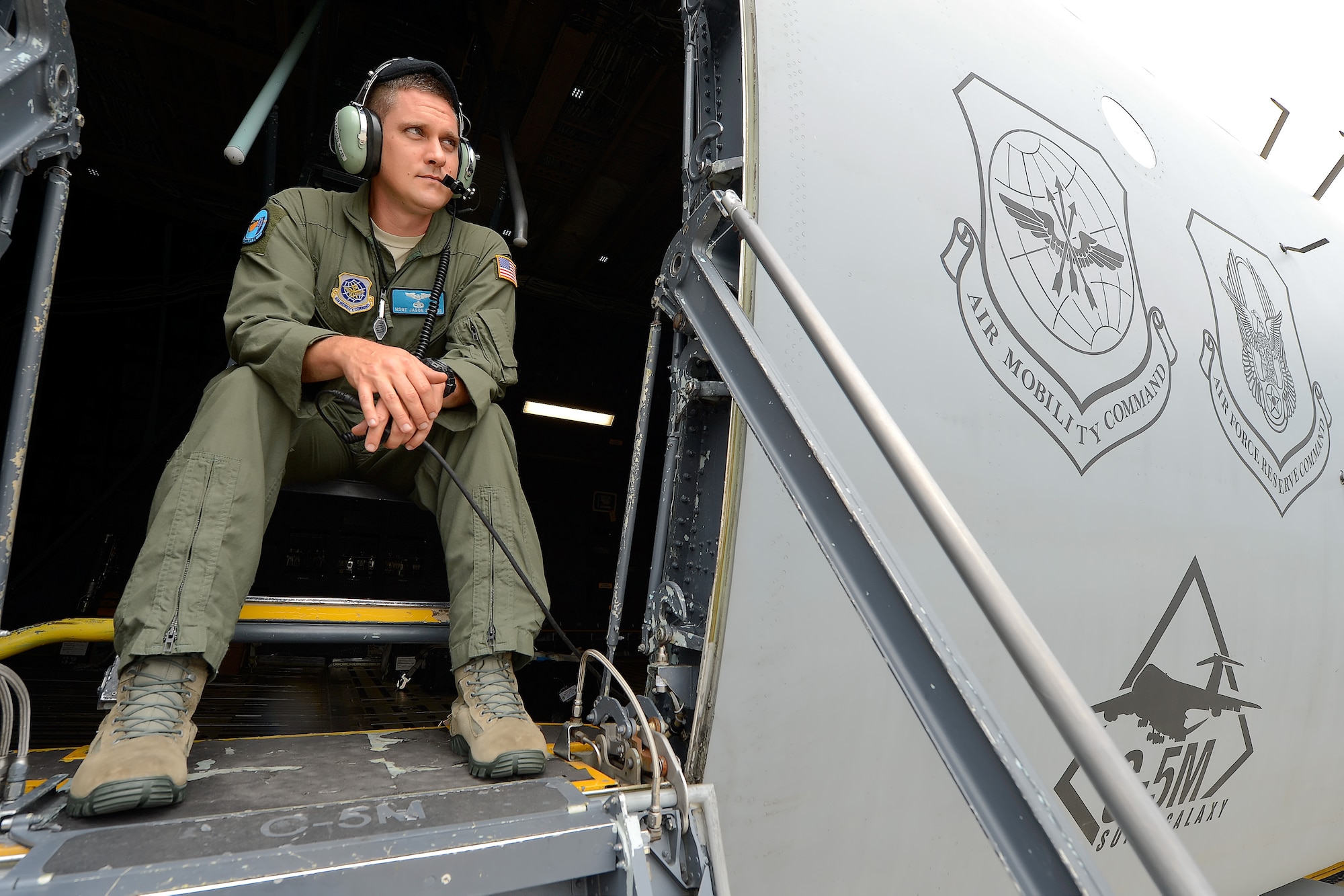 Master Sgt. Jason Staggs, 9th Airlift Squadron C-5M Super Galaxy loadmaster, acts as a safety observer from the crew entry door of the aircraft during engine start Aug. 11, 2015, at Dover Air Force Base, Del. From his vantage point Staggs is able to see problems those on the ground might not see and alert the cockpit crew immediately. (U.S. Air Force photo/Greg L. Davis) 