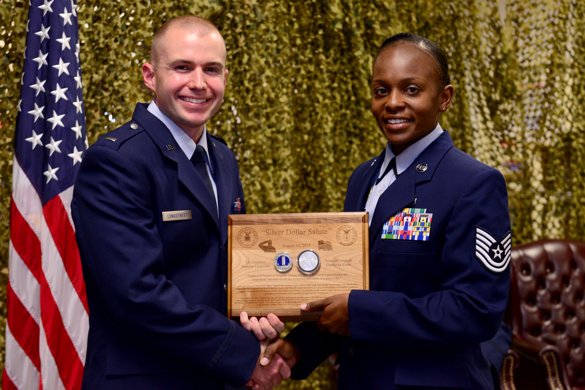 Staff Sgt. Brandon Longstreet, 2nd Medical Group public health technician, is given a silver dollar coin after receiving his first salute as an officer during a commissioning ceremony held at Barksdale Air Force Base, La., Aug. 14, 2015. The silver dollar salute is a tradition originating in the colonial era when enlisted members would help newly commissioned lieutenants get accustomed to their new unit. (U.S. Air Force Photo/Airman 1st Class Luke Hill)