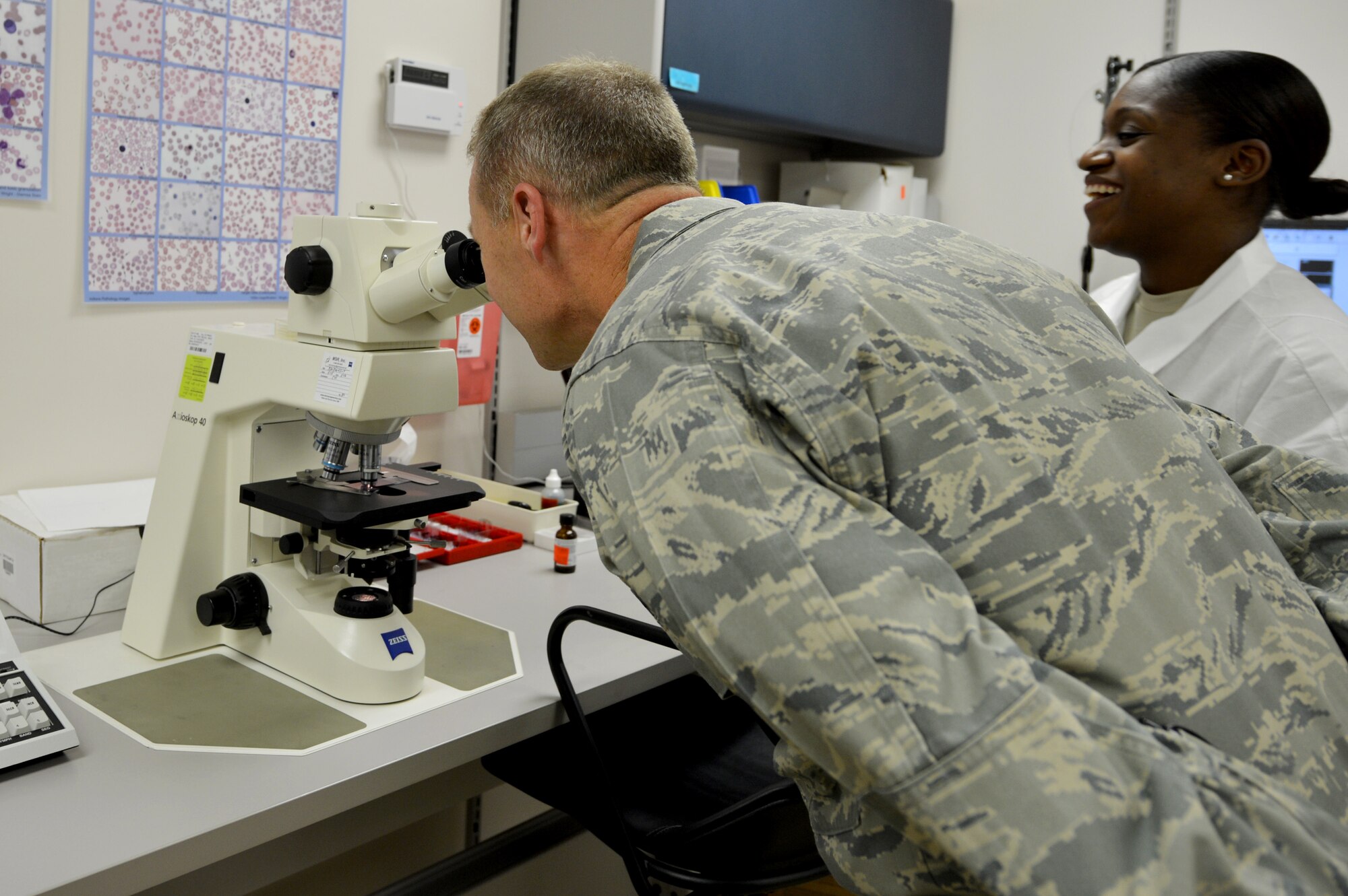 U.S. Air Force Maj. Gen. Mark Kelly, Ninth Air Force commander, looks at blood cells through a microscope while Senior Airman Brittani Payton, 20th Medical Support Squadron laboratory technician, explains what the laboratory does for Airmen during an immersion tour at Shaw Air Force Base, S.C., Aug. 6, 2015. Kelly visited 20th MDSS Public Health, Laboratory and Radiology, and the 20th Dental Squadron and was briefed by the Airmen in those career fields. (U.S. Air Force photo by Senior Airman Diana M. Cossaboom/Released)