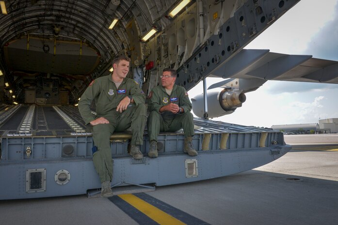 (From left to right) SrA Derek Severson, a loadmaster with the 15th Airlift Squadron, converses with MSgt. Erik Lawther, the mission support superintendent and acting first sergeant of the 15th AS, sitting on the ramp of a C-17 Globemaster III on the flight line at Joint Base Charleston, SC, Aug. 12, 2015. (U.S. Air Force photo/Airman 1st Class Thomas T. Charlton)