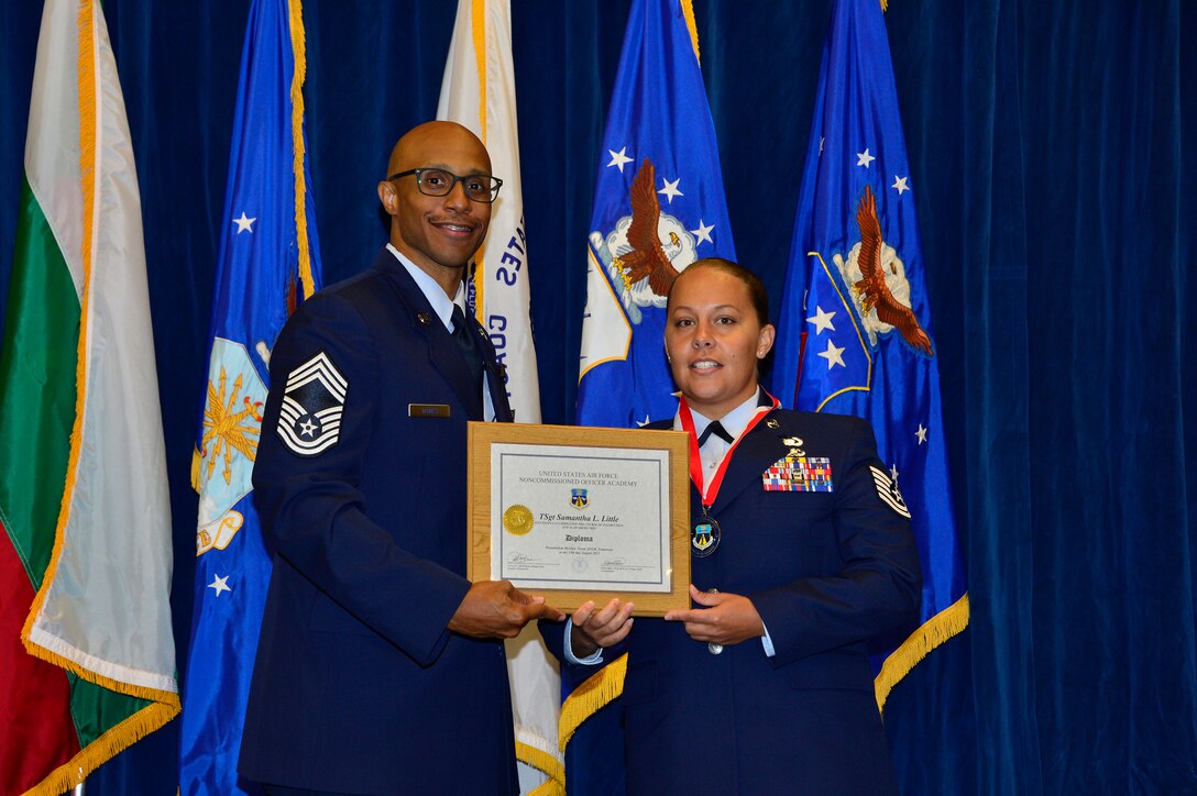 MCGHEE TYSON AIR NATIONAL GUARD BASE, Tenn. - Tech. Sgt. Samantha Little, right, receives the Distinguished Graduate Award for NCO academy Class 15-5 from Chief Master Sgt. Conrad Dawes, enlisted space operations functional manager for Air Force Reserve Command, here, August 13, 2015, at the I. G. Brown Training and Education Center. The distinguished graduate award is presented to students in the top 10 percent of the class. (U.S. Air National Guard photo by Master Sgt. Jerry Harlan/Released)
