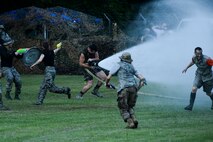 Senior Airman Michael Gilligan, 4th Civil Engineer Squadron firefighter, hoses down the competition during the 3rd annual Combat Dining In, Aug. 14, 2015, at Seymour Johnson Air Force Base, North Carolina. Gilligan’s advantage was short lived as Airmen quickly overtook his position and shut the hose down. (U.S. Air Force photo/Senior Airman Brittain Crolley)
