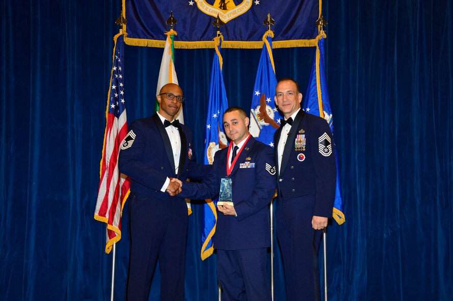 MCGHEE TYSON AIR NATIONAL GUARD BASE, Tenn. - Staff Sgt. Frankie Grullon receives the Commandant's Award for Airman leadership school Class 15-7 from Chief Master Sgt. Conrad Dawes, enlisted space operations functional manager for Air Force Reserve Command, and Chief Master Sgt. Edward Walden Sr., commandant, here August 12, 2015, at the Paul H. Lankford EPME Center. (U.S. Air National Guard photo by Master Sgt. Jerry D. Harlan/Released)