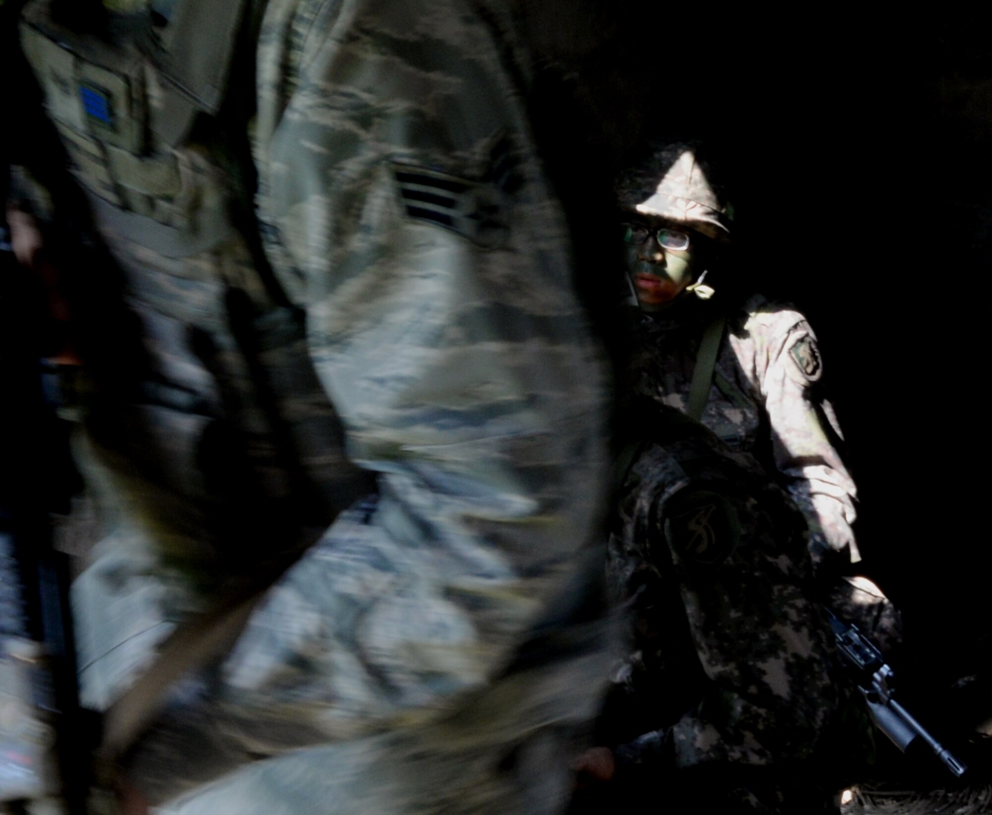 A Republic of Korea Army soldier waits with other combined operations participants before a simulated assault Aug. 18, 2015, near Pyeongtaek, South Korea. Members of the 51st SFS and ROKA worked together to perform multiple patrols throughout the day as part of the readiness exercise Beverly Midnight 15-03. (U.S. Air Force photo by Staff Sgt. Benjamin Sutton) 