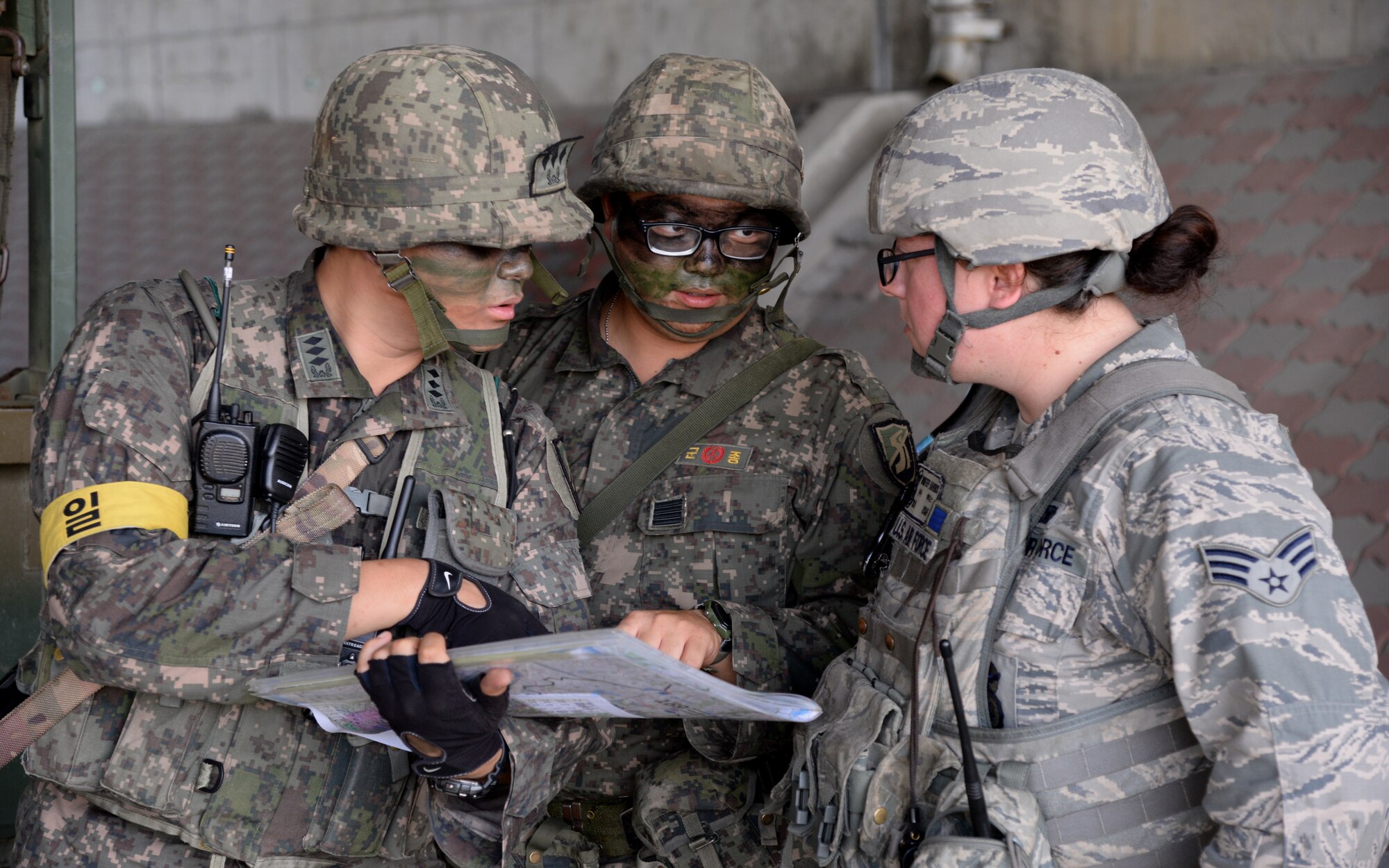 From left, Republic of Korea Army Capt. Munhu Choi, commander, Specialist Changhyeop Lee, ROKA translator, and Senior Airman Winter Harris, 51st Security Forces Squadron area supervisor, discuss patrol plans during an exercise simulation Aug. 18, 2015, near Pyeongtaek, South Korea. These combined forces enhance the ability of American and South Korean forces to make swift and coordinated tactical responses. (U.S. Air Force photo by Staff Sgt. Benjamin Sutton) 