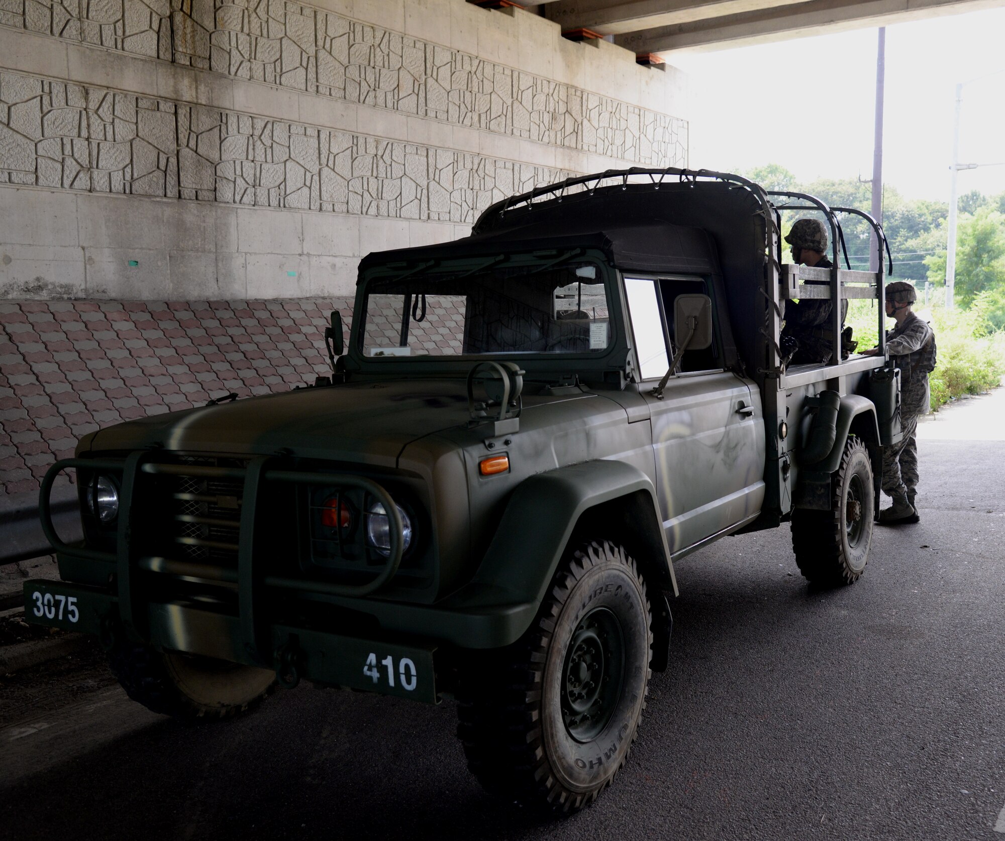 A Republic of Korea Army truck with both 51st Security Forces Squadron and ROKA members in the back sits beneath a road Aug. 18, 2015, near Pyeongtaek, South Korea. Members of the 51st SFS and ROKA worked together to perform multiple patrols during the simulated exercise in an effort to bolster combat readiness. (U.S. Air Force photo by Staff Sgt. Benjamin Sutton) 