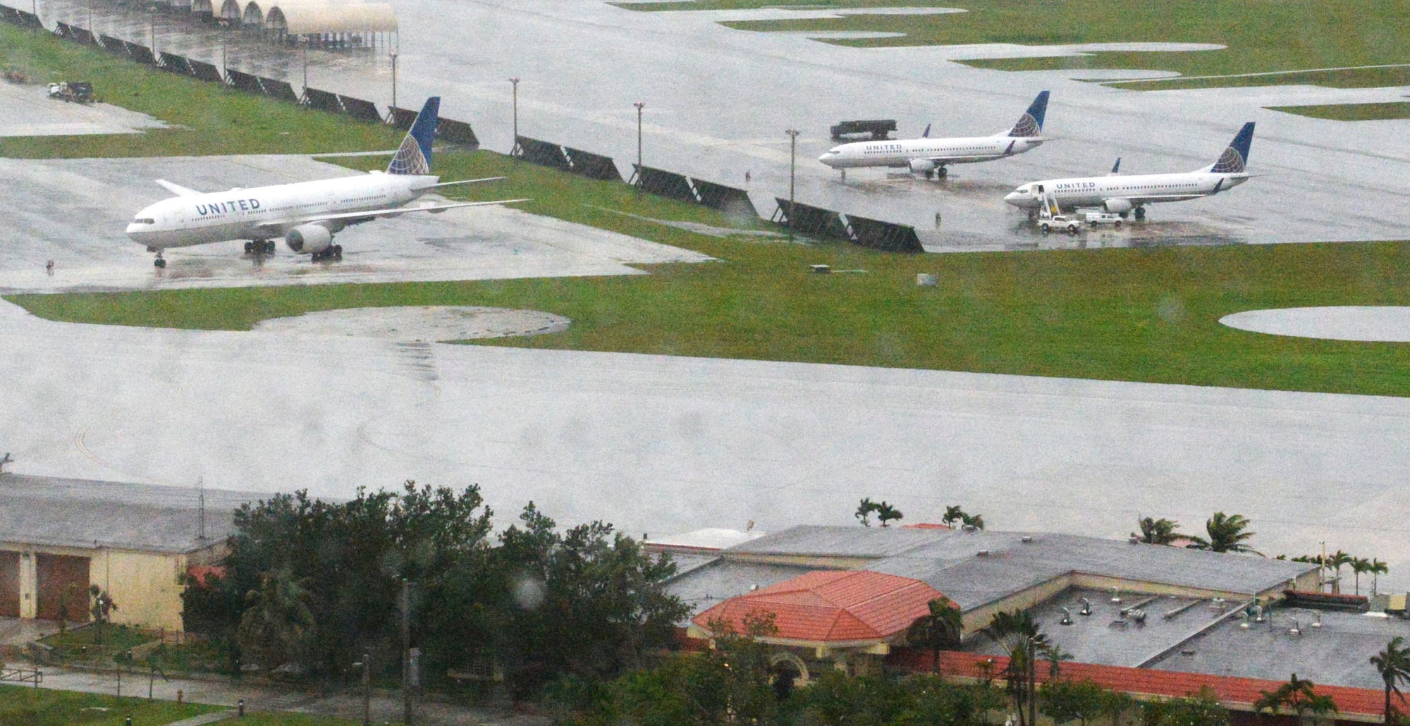 Three United Airlines aircraft are parked on the ramp Aug. 16, 2015, at Andersen Air Force Base, Guam. Three aircraft diverted to Andersen AFB due to low visibility caused by Tropical Storm Goni during the weekend. (U.S. Air Force photo by Senior Airman Joshua Smoot/Released)