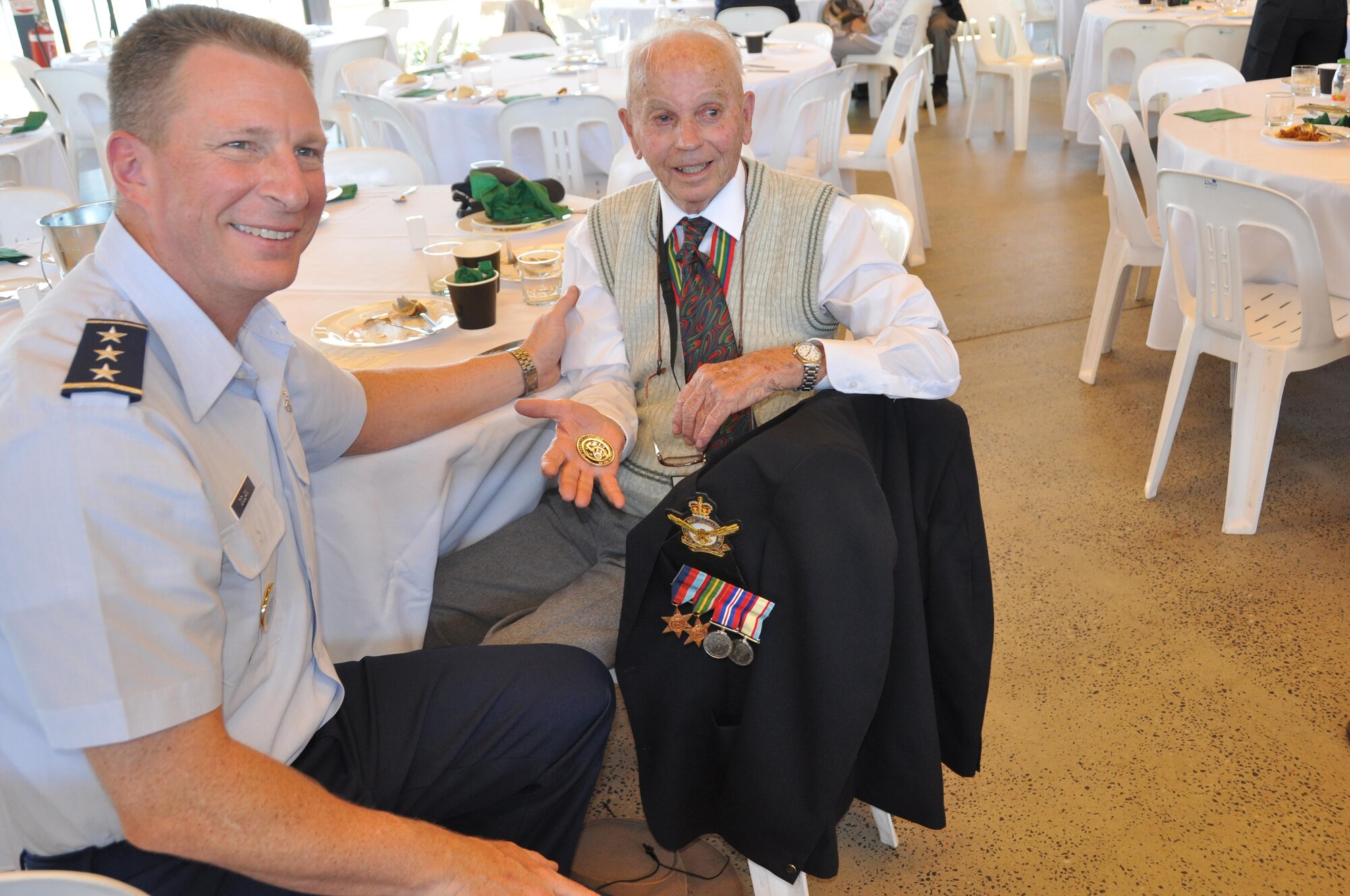 Cyril McLean, a Royal Australian Air Force World War II veteran, shows off a 5th Air Force coin presented by Lt. Gen. John Dolan, Commander, 5th Air Force, during a veterans’ luncheon hosted by Townsville, Australia, Aug. 15, 2015. The luncheon was part of several events to honor the veterans of WWII as the city commemorated the 70th anniversary of the end of the war. (U.S. Air Force photo by Capt. George M. Tobias/Released)