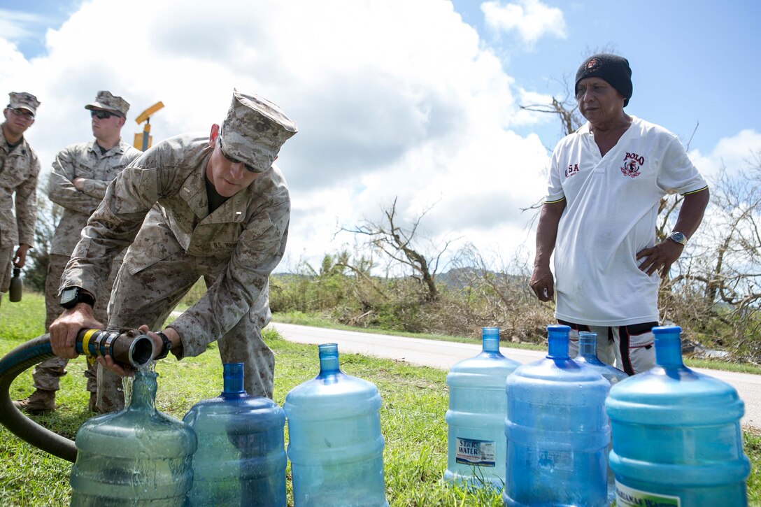 U.S. Marine 1st Lt. William Tidd, with Combat Logistics Battalion 31, 31st Marine Expeditionary Unit, distributes water to local civilians as part of typhoon relief efforts in Saipan, Aug. 11, 2015. The 31st MEU and the ships of the Bonhomme Richard Amphibious Ready Group are assisting the Federal Emergency Management Agency with distributing emergency relief supplies to Saipan after the island was struck by Typhoon Soudelor, Aug. 2-3. (U.S. Marine Corps photo by Lance Cpl. Brian Bekkala/Released.)