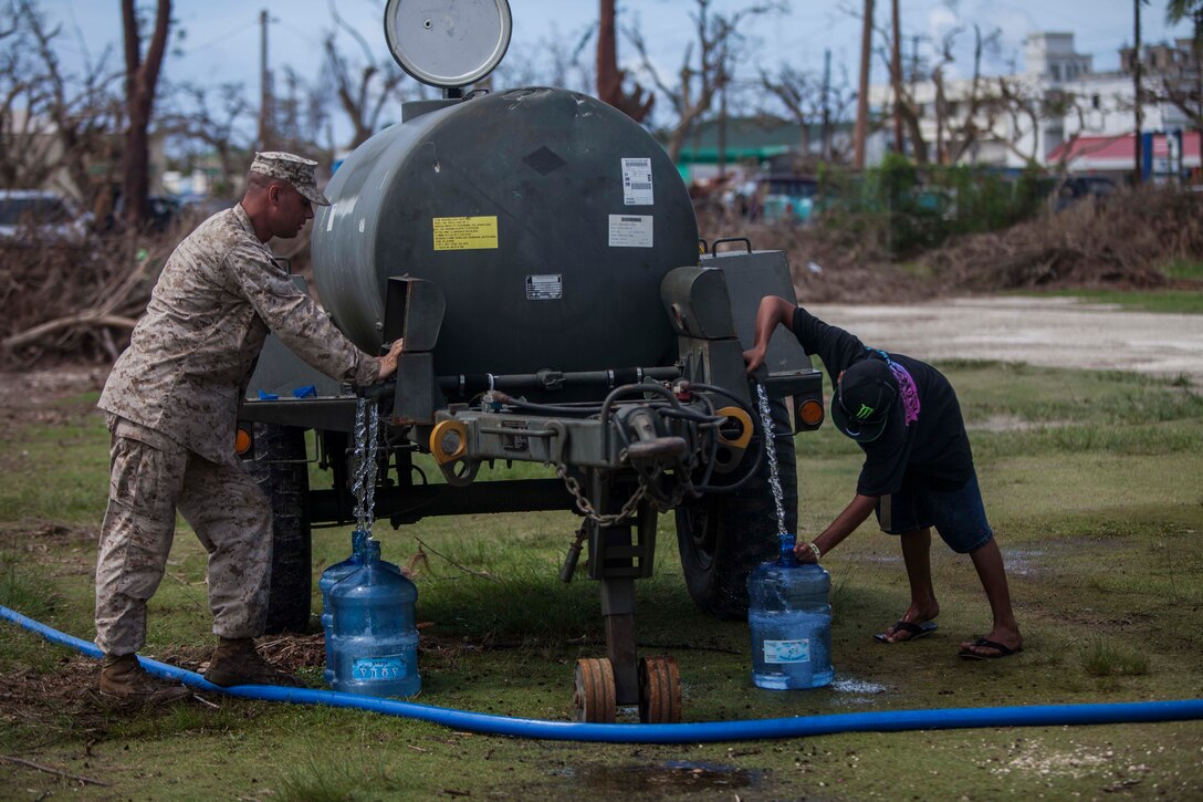 U.S. Marine Gunnery Sgt. Randy Weiss with Combat Logistics Battalion 31, 31st Marine Expeditionary Unit, fills water jugs during typhoon relief efforts in Saipan, Aug. 12, 2015. The 31st MEU and the ships of the Bonhomme Richard Amphibious Ready Group are assisting local and federal agencies with distributing emergency relief supplies to Saipan after the island was struck by Typhoon Soudelor Aug. 2-3. (U.S. Marine Corps photo by Gunnery Sgt. Ismael Pena/Released)