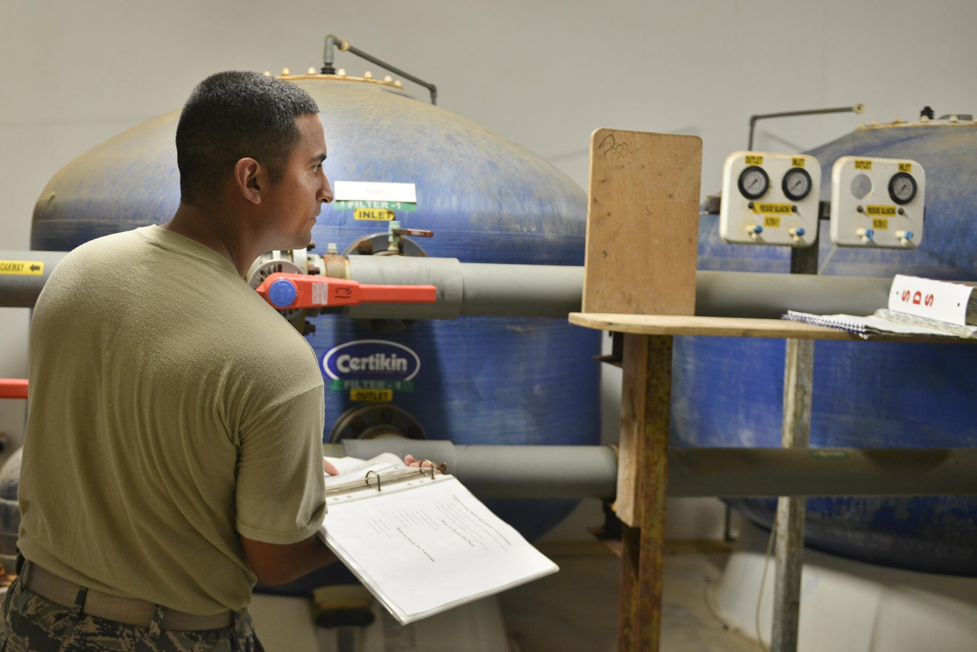 Staff Sgt. Daniel Hernandez, 379th Expeditionary Civil Engineer Squadron water and fuels, goes through a step-by-step checklist to properly flush the water filtration system for a pool August 14, 2015 at Al Udeid Air Base, Qatar.  With the high number of deployed members here at Al Udeid, the 379th ECES water and fuels airmen stay busy day and night keeping the systems running to support the base. (U.S. Air Force photo/ Staff Sgt. Alexandre Montes)