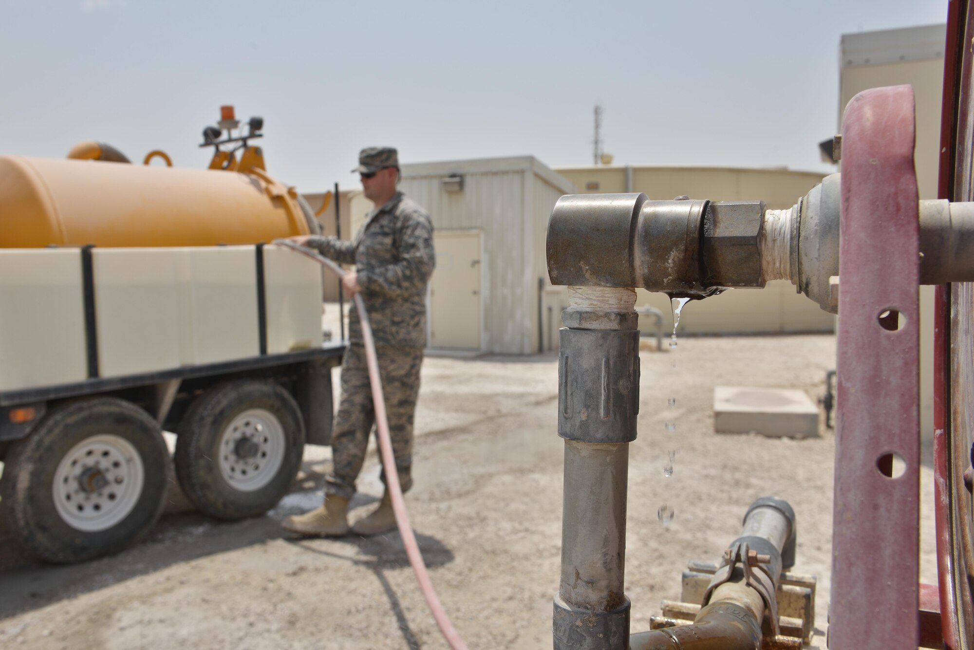 Airman 1st Class Joshua Rickerd, 379th Expeditionary Civil Engineer Squadron water and fuels, fills a reservoir with water prior to completing the daily lift station maintenance August 14, 2015 at Al Udeid Air Base, Qatar. Waste water is tested and monitored daily to ensure the systems are running smoothly and do not back up. With the high number of deployed members here at Al Udeid, the 379th ECES water and fuels airmen stay busy day and night keeping the systems running to support the base. (U.S. Air Force photo/ Staff Sgt. Alexandre Montes)