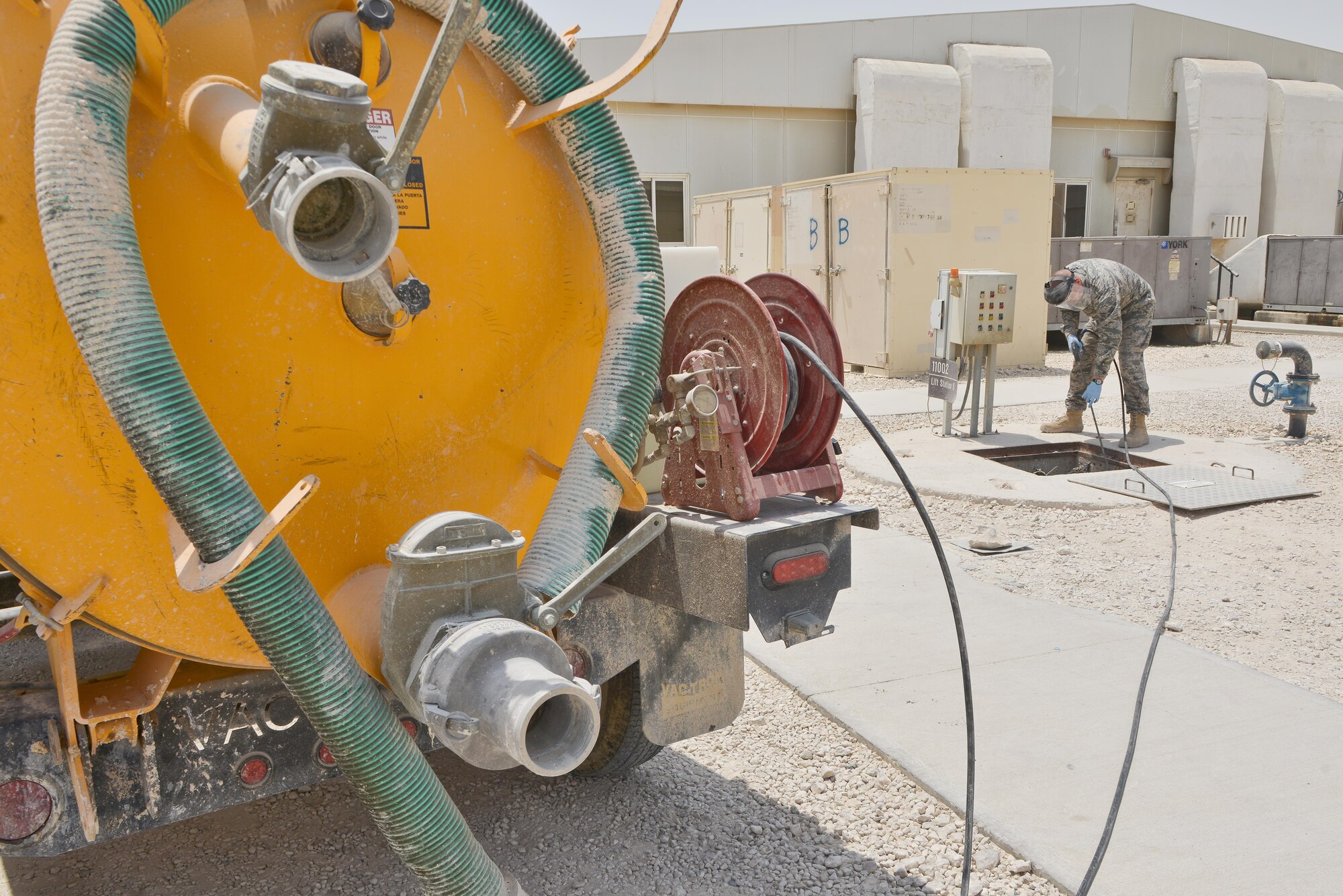 Airman 1st Class Joshua Rickerd, 379th Expeditionary Civil Engineer Squadron water and fuels, sprays down a lift station with water to keep sewage from backing up the plumbing system  August 14, 2015 at Al Udeid Air Base, Qatar. Waste water is tested and monitored daily to ensure the systems are running smoothly and do not back up. With the high number of deployed members here at Al Udeid, the airmen stay busy day and night keeping the septic systems running to support the base. (U.S. Air Force photo/ Staff Sgt. Alexandre Montes)