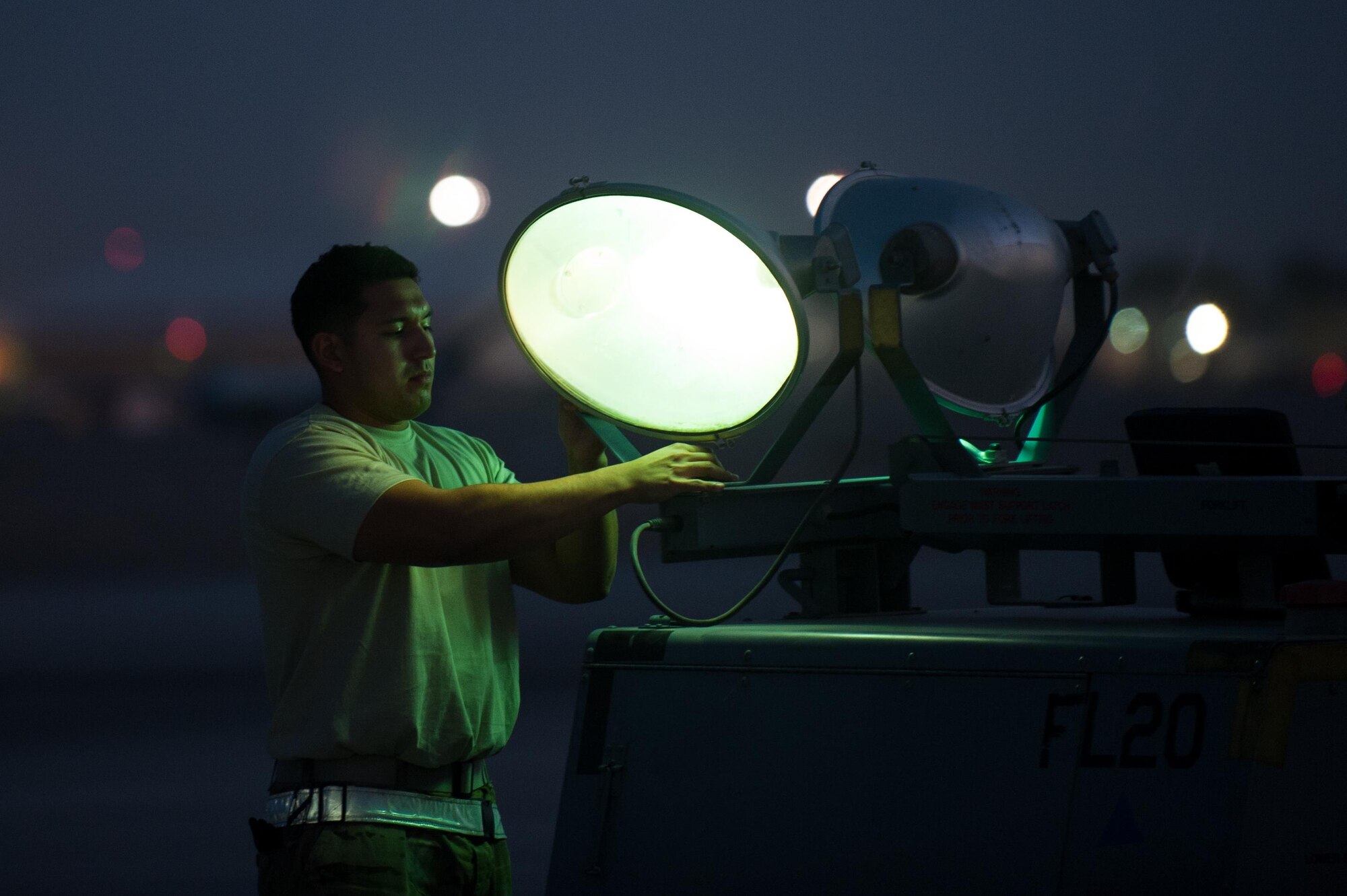 A U.S. Airman assigned to the 62nd Expeditionary Reconnaissance Squadron adjusts the lights during Remotely Piloted Airplane operations at Kandahar Airfield, Afghanistan, Aug. 13, 2015.  The 62nd ERS operates the MQ-1B Predator and MQ-9 Reaper aircraft and provides world-class close air support, intelligence, surveillance and reconnaissance capabilities in Afghanistan. (U.S. Air Force photo by Tech. Sgt. Joseph Swafford/Released) 