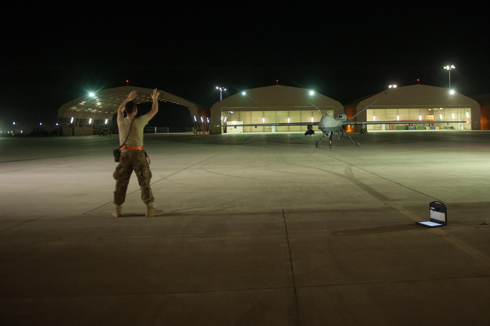 A U.S. Airman assigned to the 62nd Expeditionary Reconnaissance Squadron directs a MQ-9 Reaper aircraft at Kandahar Airfield, Afghanistan, Aug. 13, 2015.  The 62nd ERS operates the MQ-1B Predator and Reaper aircraft and provides world-class close air support, intelligence, surveillance and reconnaissance capabilities in Afghanistan. (U.S. Air Force photo by Tech. Sgt. Joseph Swafford/Released) 