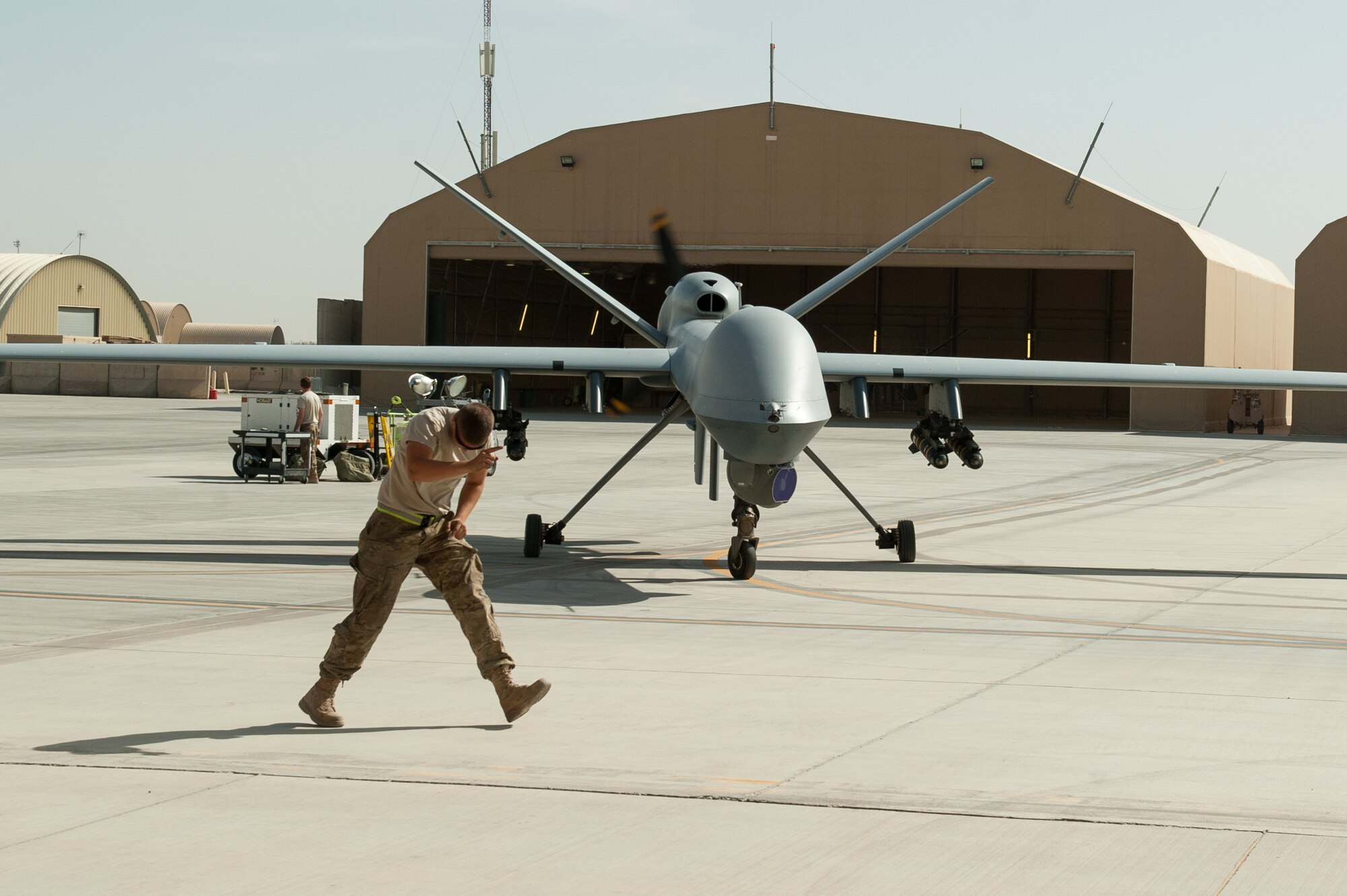 A U.S. Airman assigned to the 62nd Expeditionary Reconnaissance Squadron directs a MQ-9 Reaper aircraft at Kandahar Airfield, Afghanistan, Aug. 14, 2015.  The 62nd ERS operates the MQ-1B Predator and Reaper aircraft and provides world-class close air support, intelligence, surveillance and reconnaissance capabilities in Afghanistan. (U.S. Air Force photo by Tech. Sgt. Joseph Swafford/Released)