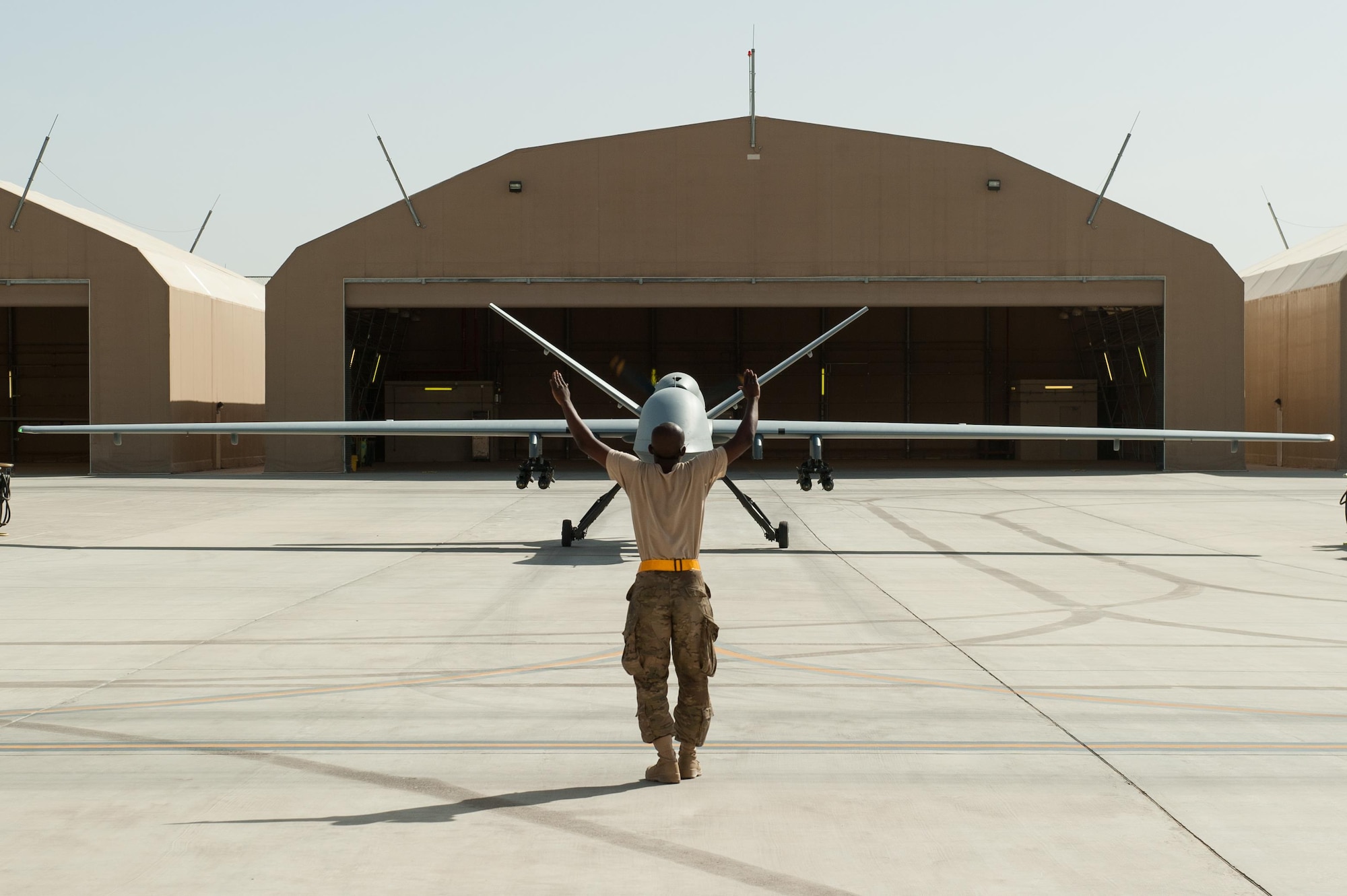 A U.S. Airman assigned to the 62nd Expeditionary Reconnaissance Squadron directs a MQ-9 Reaper aircraft at Kandahar Airfield, Afghanistan, Aug. 14, 2015.  The 62nd ERS operates the MQ-1B Predator and Reaper aircraft and provides world-class close air support, intelligence, surveillance and reconnaissance capabilities in Afghanistan. (U.S. Air Force photo by Tech. Sgt. Joseph Swafford/Released)