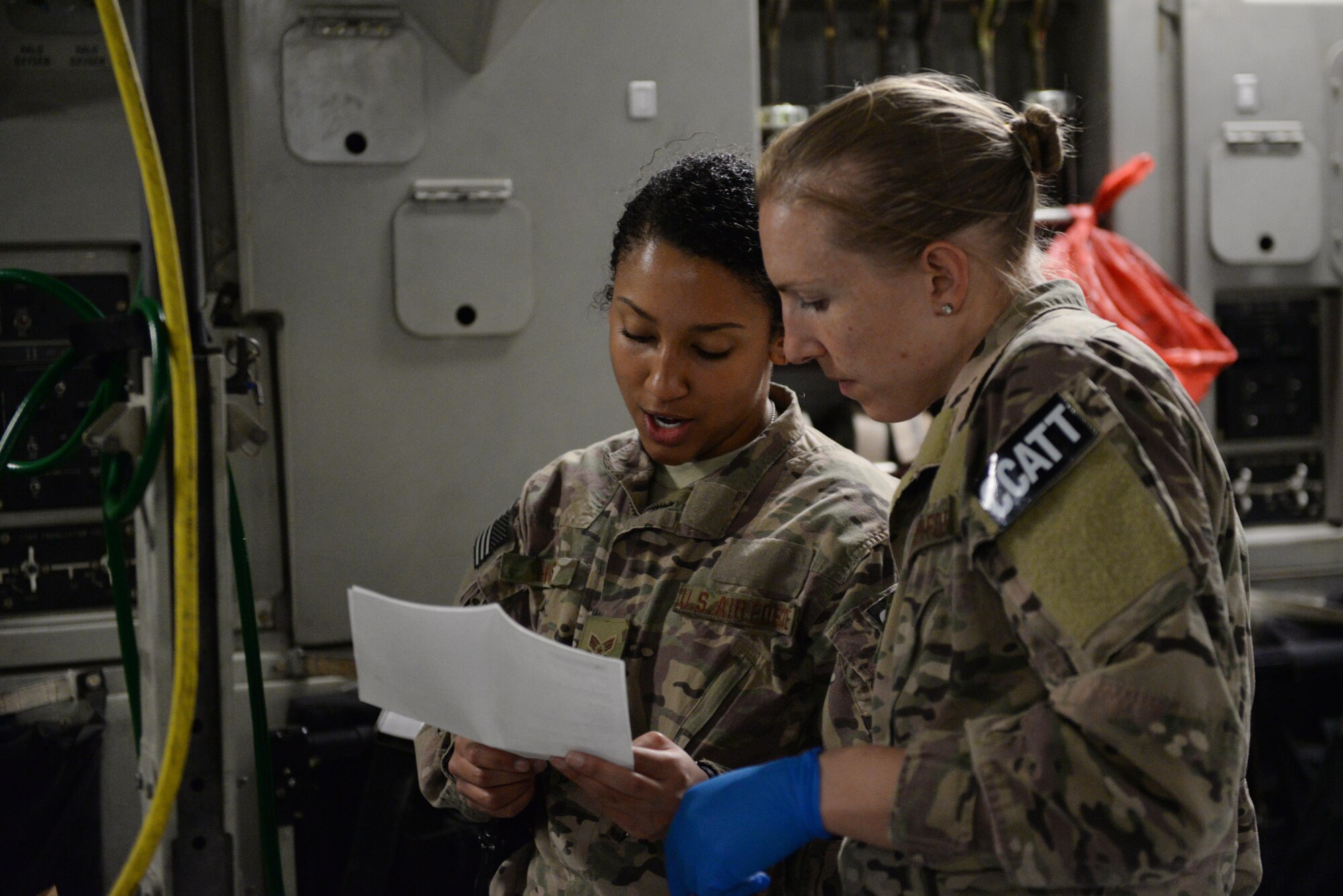 U.S. Capt. Deann Hoelscher, right, 455th Expeditionary Aeromedical Evacuation Squadron Critical Care Air Transport Team physician deployed from the 60th Medical Group at Travis Air Force Base, California, Senior Airman Natalie Hives, left, 455th EAES CCATT respiratory therapist deployed from the 60th Medical Group at Travis Air Force Base, California, review a patient’s chart prior to an aeromedical evacuation mission aboard a C-17 Globemaster III aircraft from Bagram Airfield, Afghanistan, to Ramstein Air Base, Germany, Aug. 8, 2015. The 455th EAES’ CCATT is a three-person, highly specialized medical team consisting of a physician who specializes in an area of critical care or emergency medicine, a critical care nurse and a respiratory therapist. The CCATT is charged with providing critical care to the sick and wounded as they are moved thousands of miles onboard U.S. cargo aircraft to receive full-time care elsewhere. (U.S. Air Force photo by Maj. Tony Wickman/Released) 