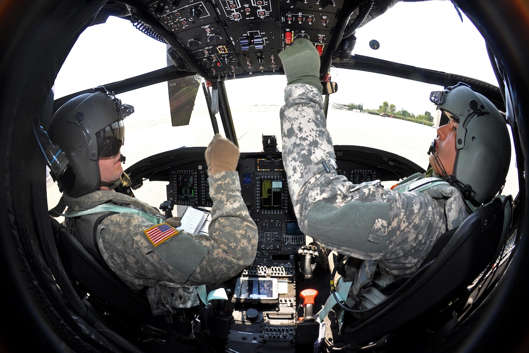 Army Chief Warrant Officer 4 Craig Hannon, left, and Army Chief Warrant Officer 2 Daniel Reyna perform preliminary flight checks inside their CH-47 Chinook helicopter at Redding Airport in Redding, Calif., Aug. 19, 2015. Hannon and Reyna are pilots assigned to the California Army National Guard's 1st Battalion, 126th Aviation Regiment. California Army National Guard photo by Staff Sgt. Eddie Siguenza