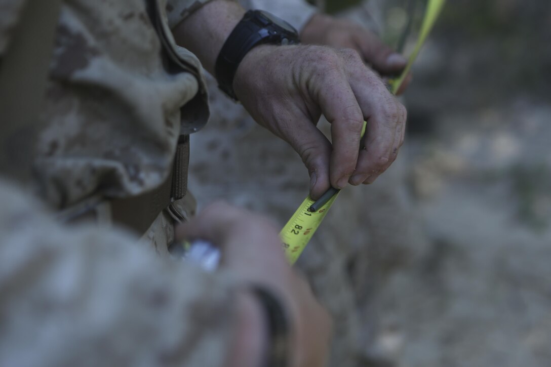 Marines from 2nd Combat Engineer Battalion measure a strand of detonation cord to test the amount of time it takes to burn during a fell stranding timber demolition range at Fort A.P. Hill, Va., Aug. 14, 2015. The Marines brought down eight trees using high explosives in order to train on one method of obstacle creation and area clearing as part of the battalion’s deployment for training exercise to enhance their basic infantry and engineer skills in preparation for upcoming deployments. (U.S. Marine Corps photo by Cpl. Michelle Reif/Released)