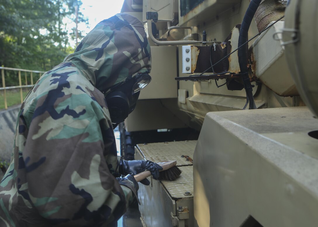 A Marine with 2nd Combat Engineer Battalion scrubs down a tactical vehicle while wearing Mission Oriented Protective Posture gear at Fort A.P. Hill, Va., Aug. 16, 2015. The Marines conducted the training in order to practice decontamination procedures involving Chemical Biological Radiological and Nuclear defense as part of a deployment for training exercise where the battalion trained on provisional infantry skills to prepare for upcoming deployments. (U.S. Marine Corps photo by Cpl. Michelle Reif/Released.)
