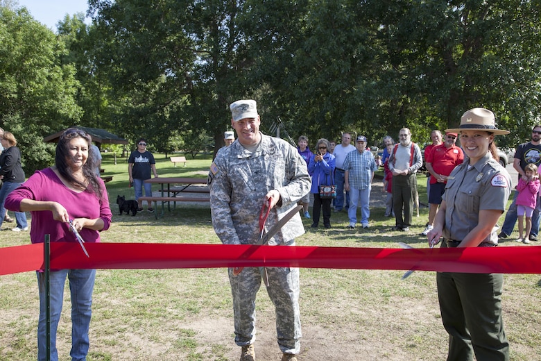 Sandy Skinaway, Sandy Lake Tribe chairwoman, Col. Dan Koprowski, St. Paul District commander, and Tammy Johnson, Sandy Lake Park Manager, conduct a ribbon cutting ceremony, officially rededicating the Sandy Lake visitor center August 17, 2015. The center, a former lock house located next to the dam, has artifacts and information about the region’s history. Corps staff spent the past year updating the displays and artifacts to better communicate the centuries of history that has occurred around the site.