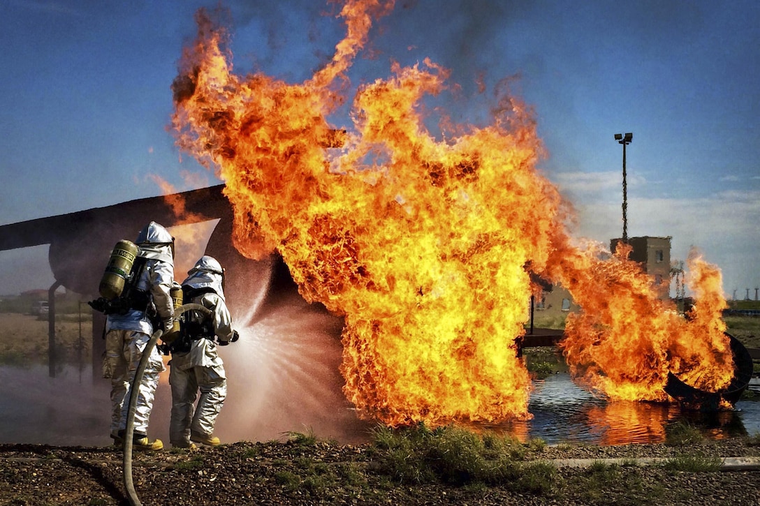 Air Force commandos practice extinguishing an aircraft fire during an exercise on Cannon Air Force Base, N.M., Aug. 14, 2015. The commandos, assigned to the 27th Special Operations Civil Engineer Squadron, conducted joint fire training on base with the Clovis, N.M., fire department as part of a mutual aide agreement. U.S. Air Force photo by Staff Sgt. Alexxis Mercer