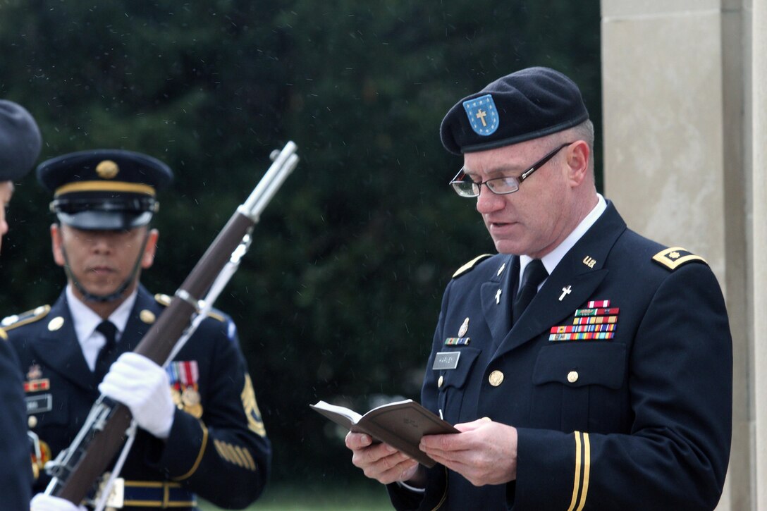 Maj. Doug Harvey of Louisville, Ky., deputy command chaplain, 84th Training Command, Fort Knox, Ky., reads the invocation in a brief snow shower during the Zachary Taylor National Cemetery wreath laying ceremony Monday, Nov. 24, 2014, in Louisville, Ky. (Photo by Clinton Wood, 84th TC Public Affairs)